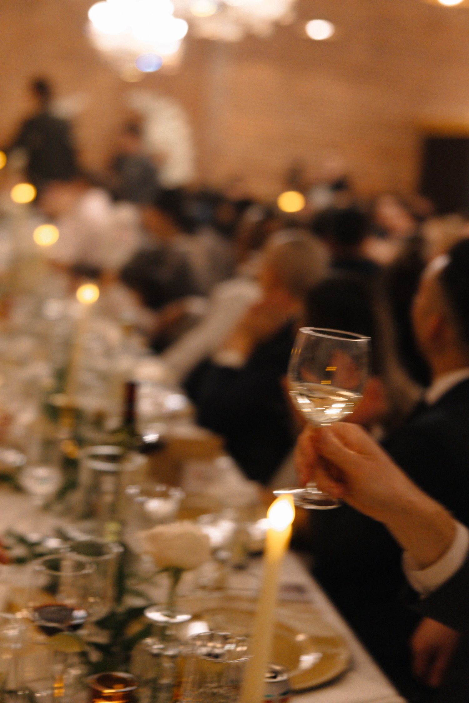 Elegant wedding reception table setting with wine glasses and candlelight creating a romantic atmosphere.