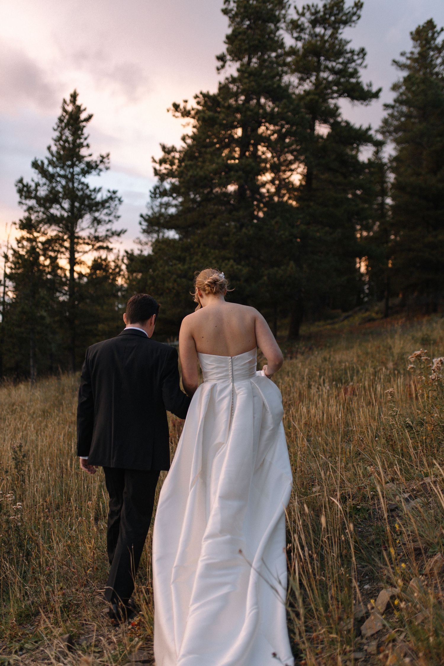 bride and groom holding hands, walking up hill