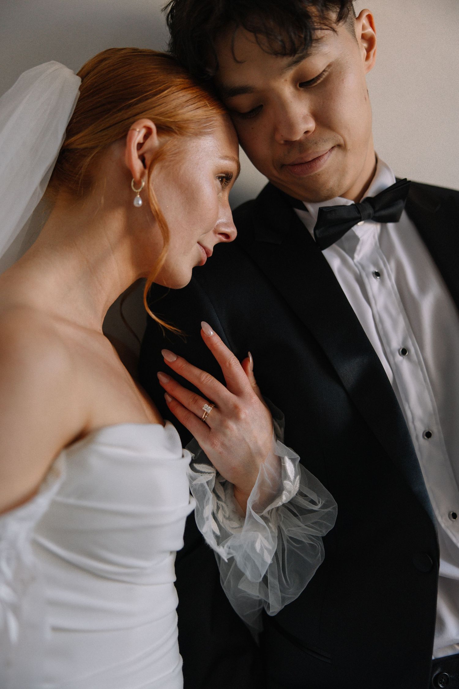 Romantic close-up of couple sharing an intimate moment in formal wedding attire.