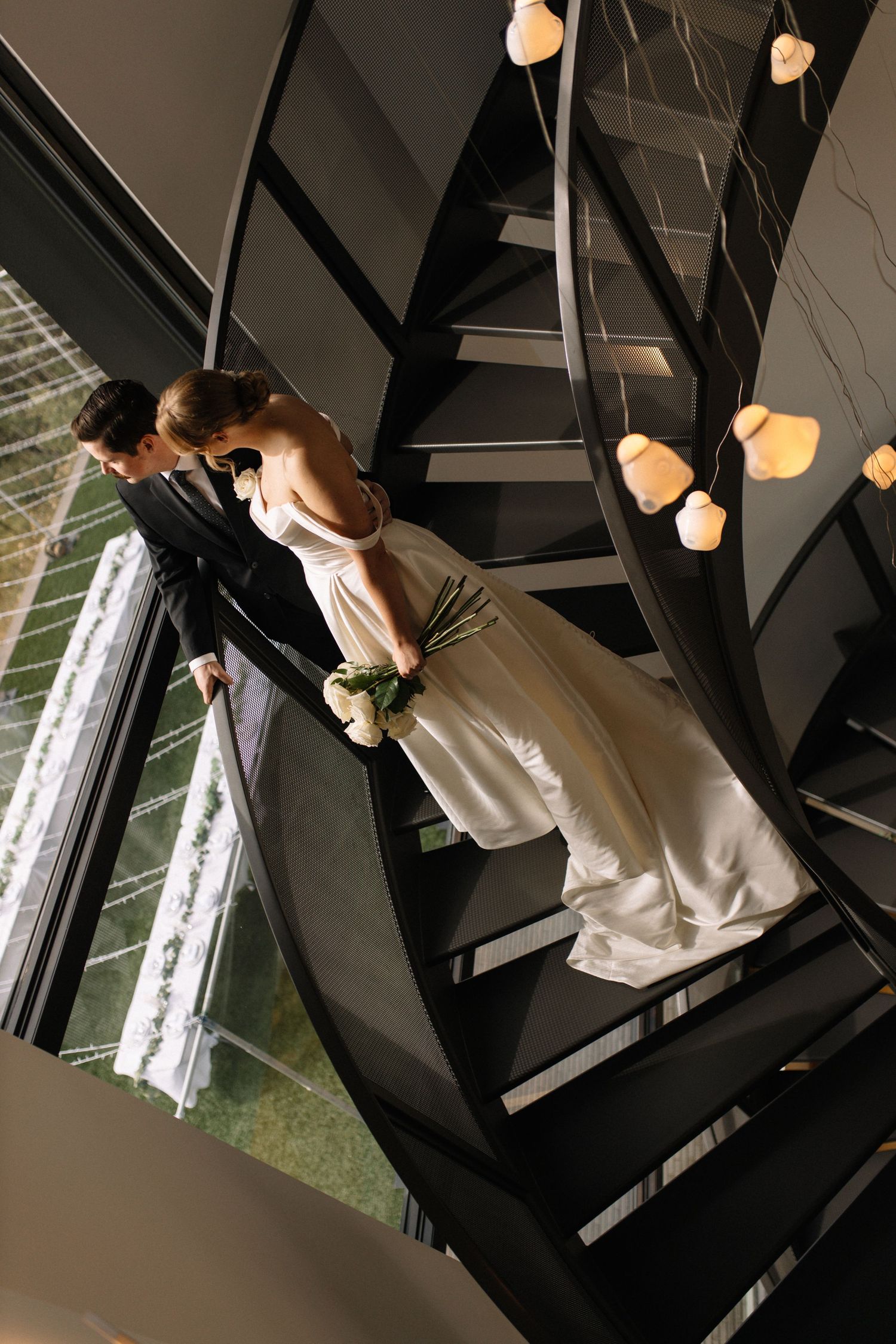 bride and groom on star case, looking out the window