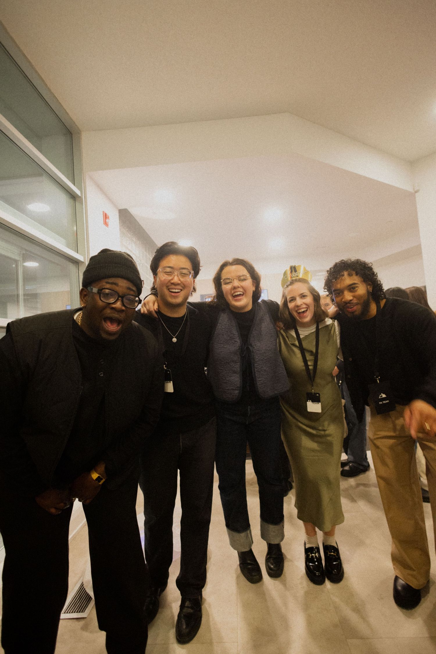 Group of people jumping together in a hallway creating a playful silhouette effect.