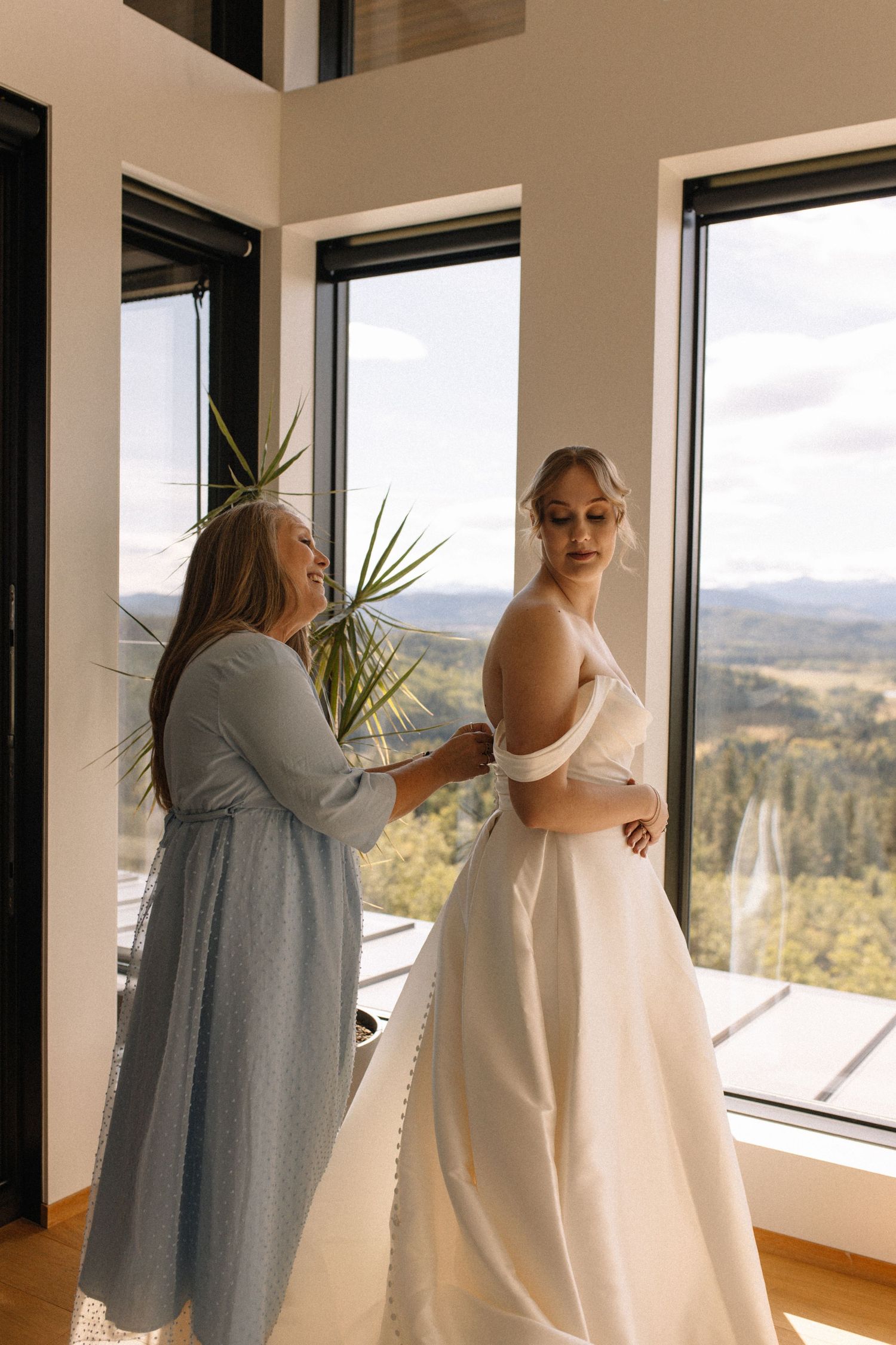 mother of bride zipping up brides dress