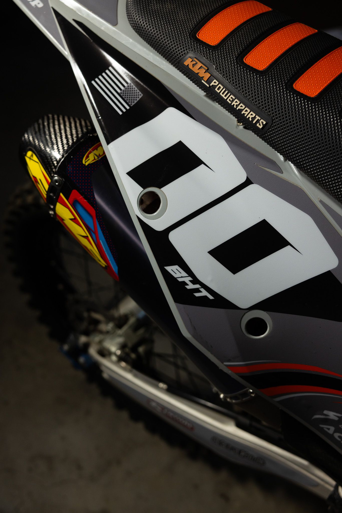 Close-up shots of black and orange downhill mountain bike boots featuring angular design elements and vents.