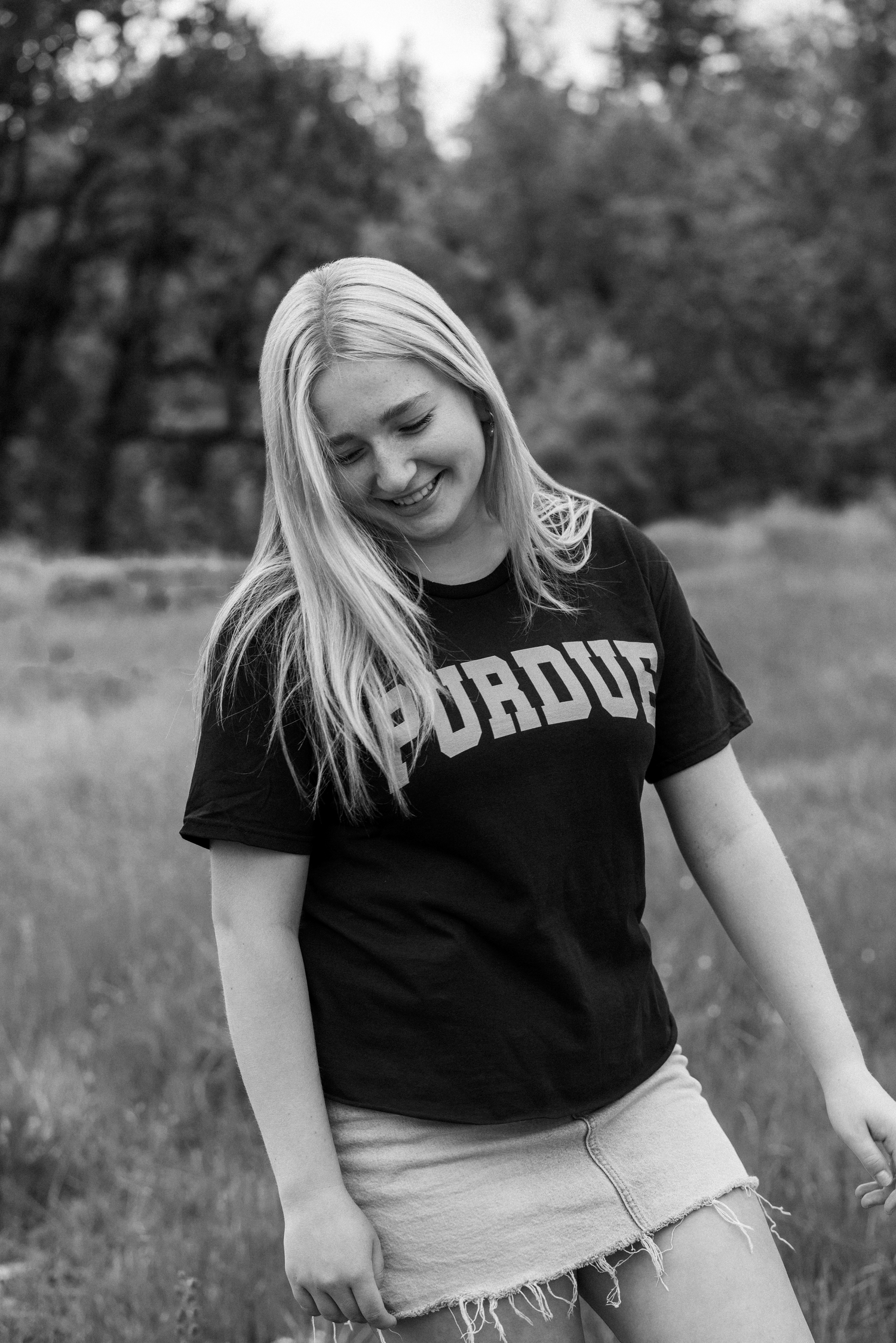 Black and white photo series showing dance-like movement poses in an outdoor field setting against blurred trees.
