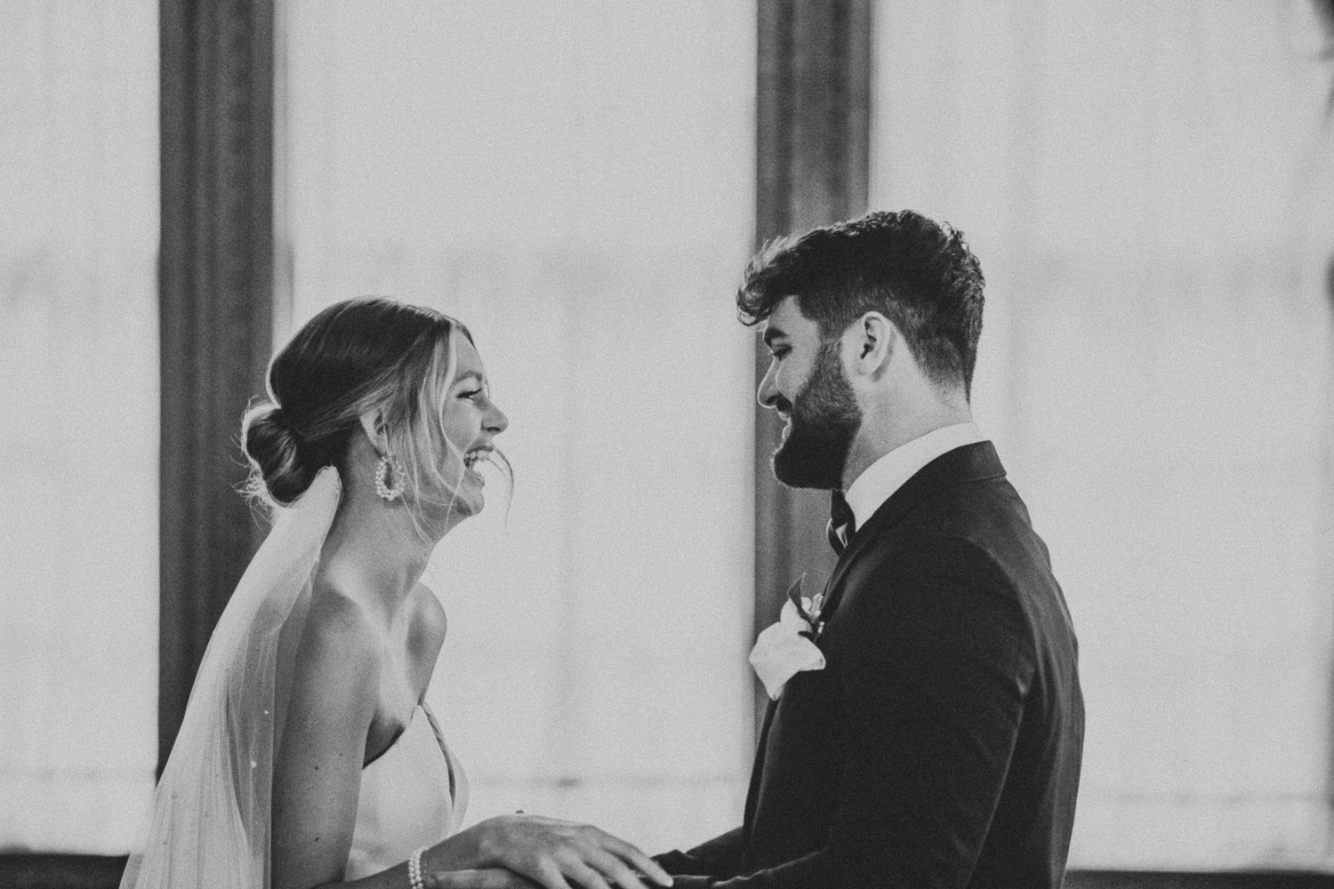 Black and white wedding portrait captures an intimate moment between newlyweds.