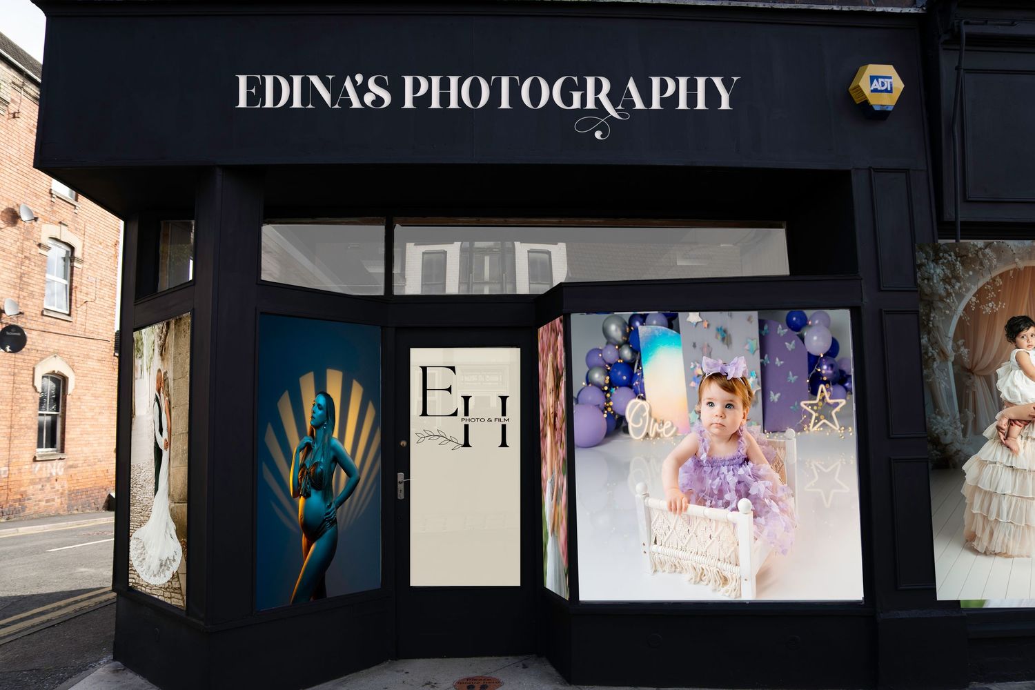 Edinas Photography studio storefront with black facade displaying portrait and wedding photography samples in window displays.