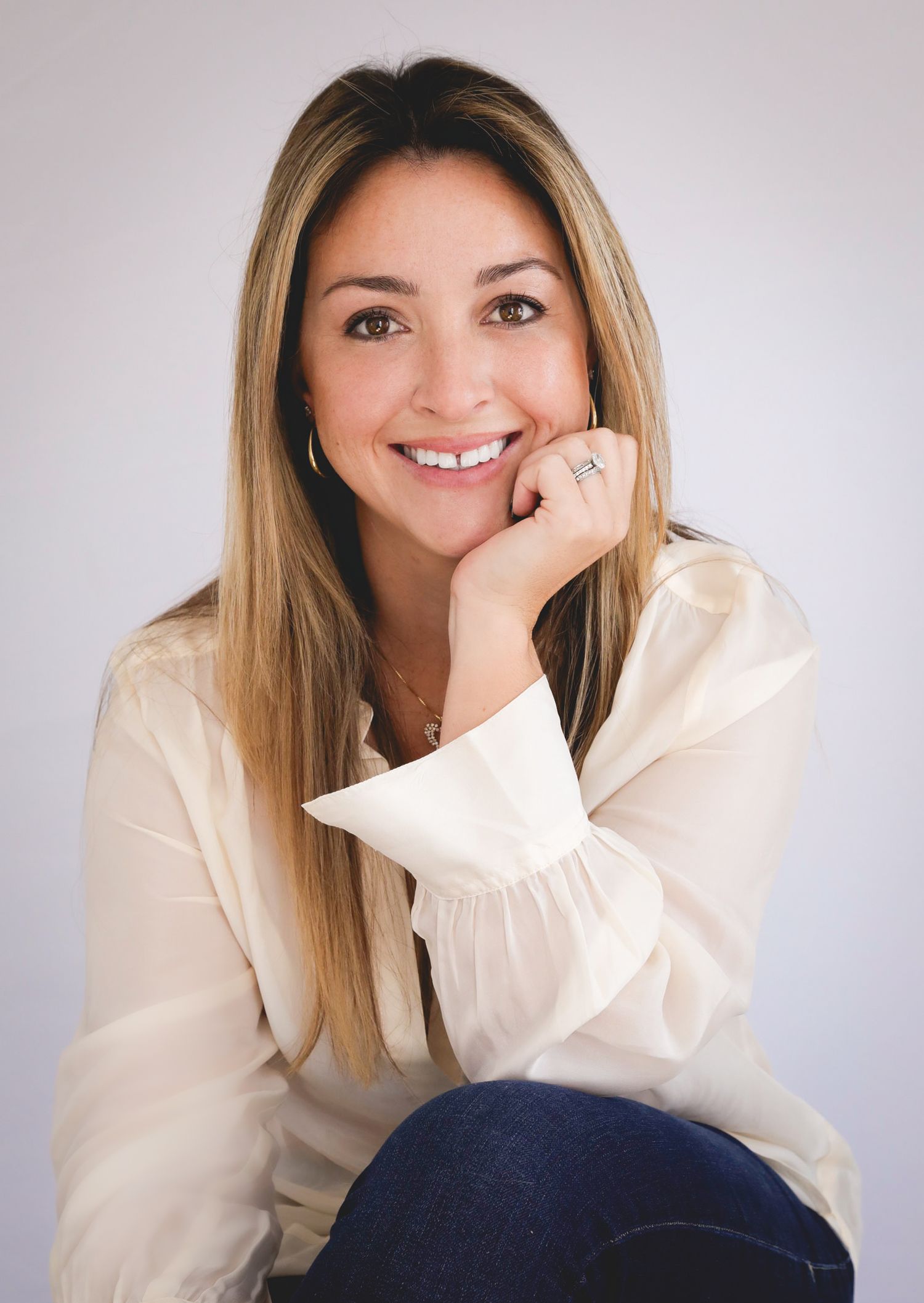 Portrait series of a person in white clothing showing various cheerful expressions against neutral background.