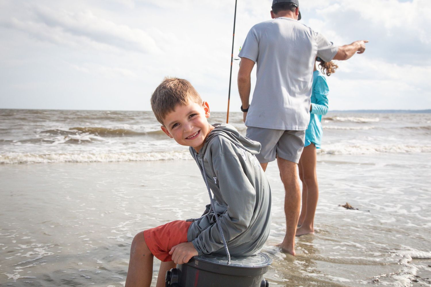 People enjoying a day of beach fishing along the ocean shore.