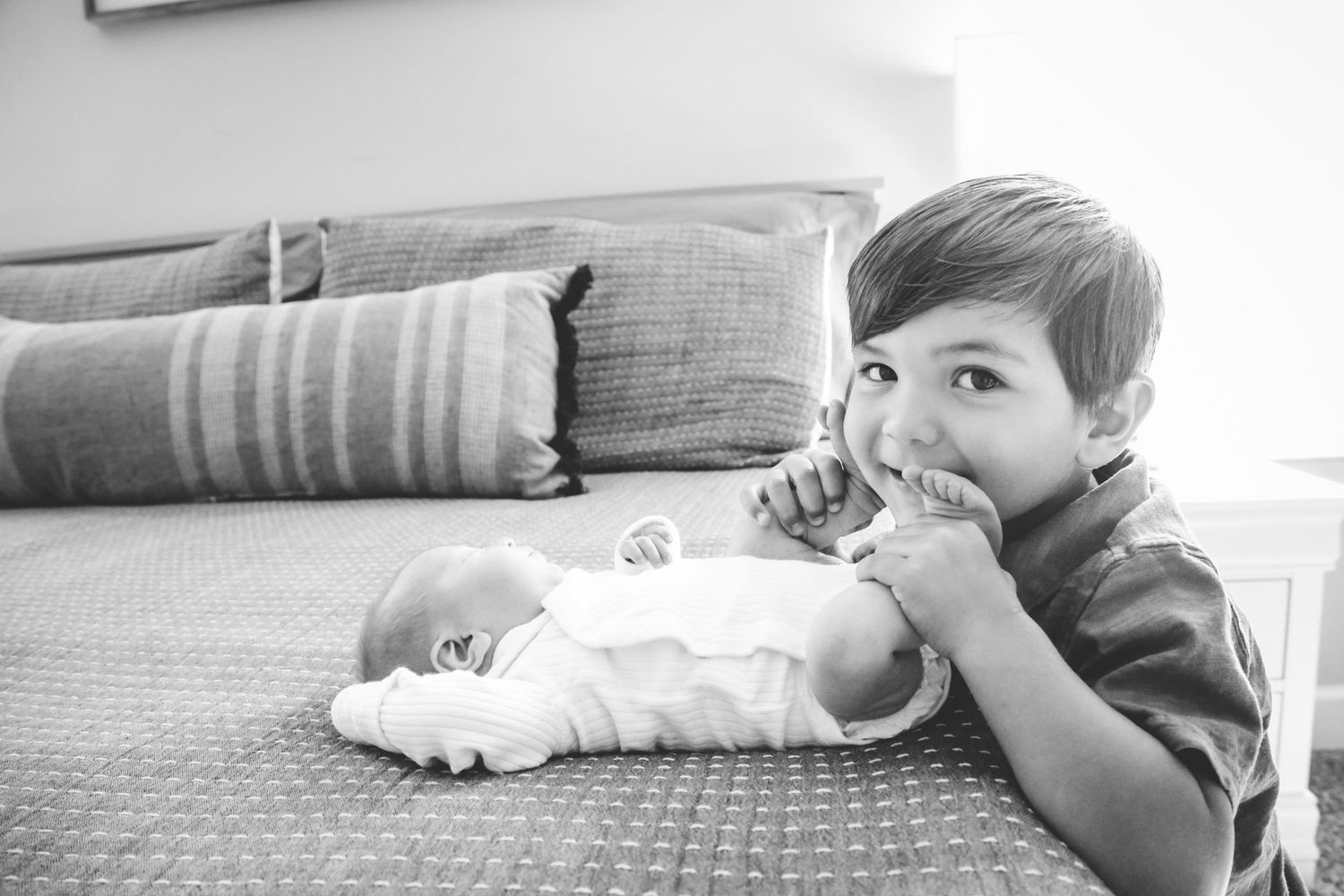 A series of black and white photographs showing a young child lying on a couch in different positions.