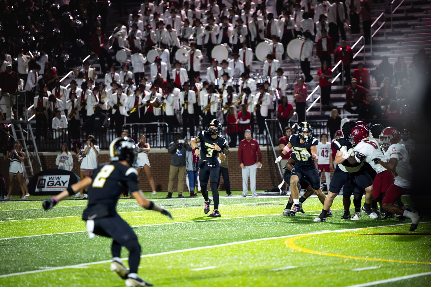 A sequence of football game action shots showing players in motion during a nighttime match under stadium lights.