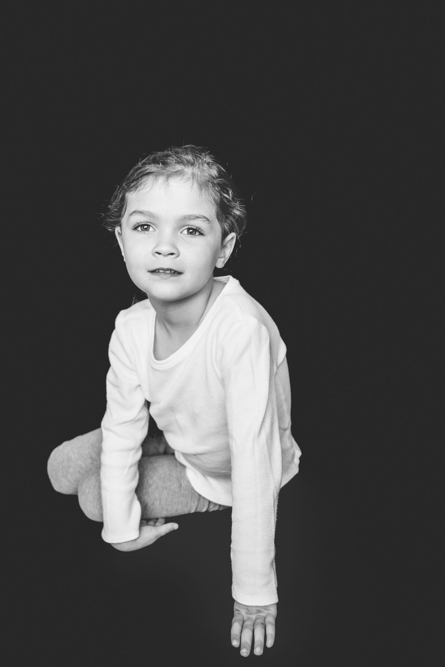 Sequential black and white photos show a child crawling and moving against a dark backdrop.