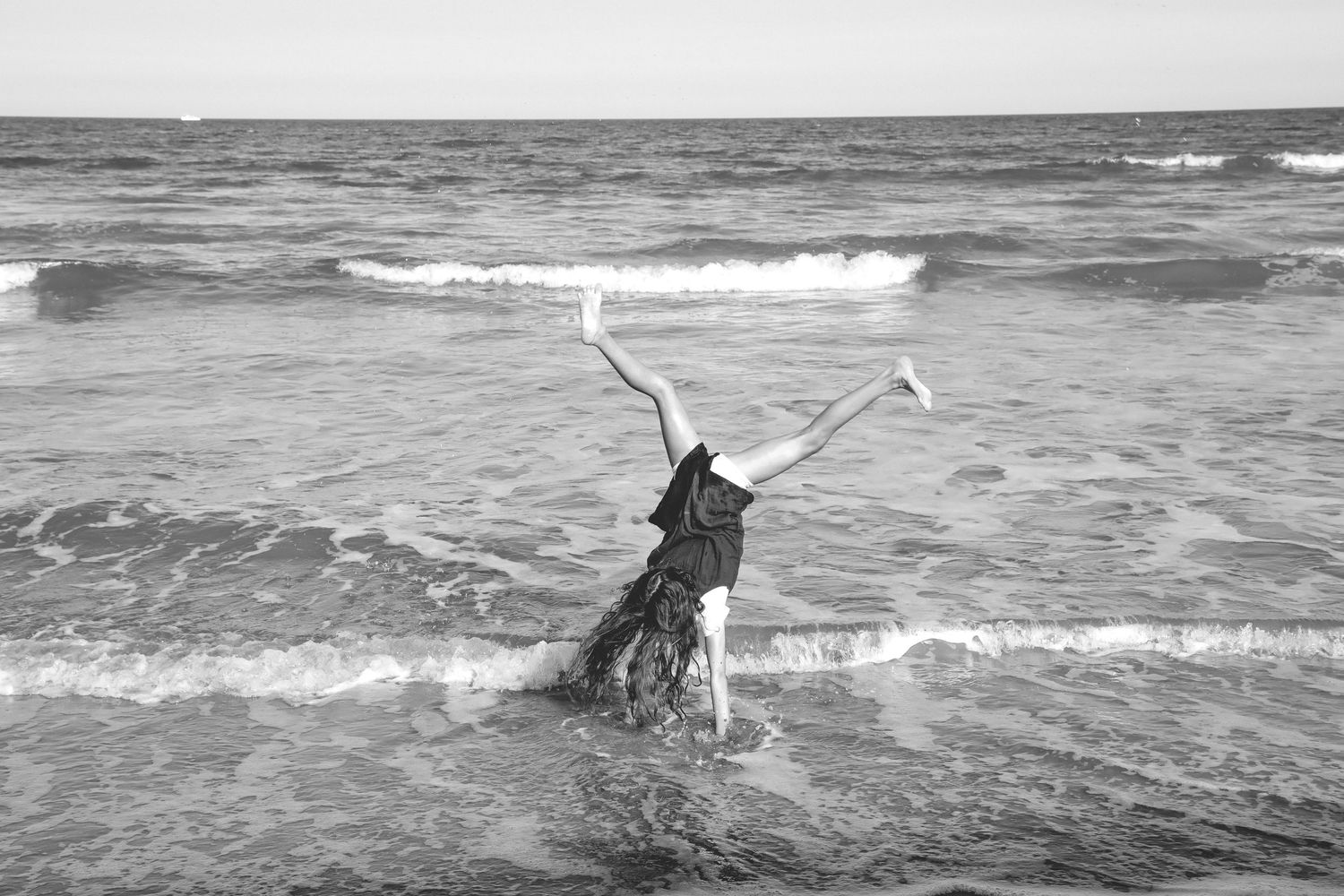 Series of black and white beach scenes with waves crashing along the shoreline.