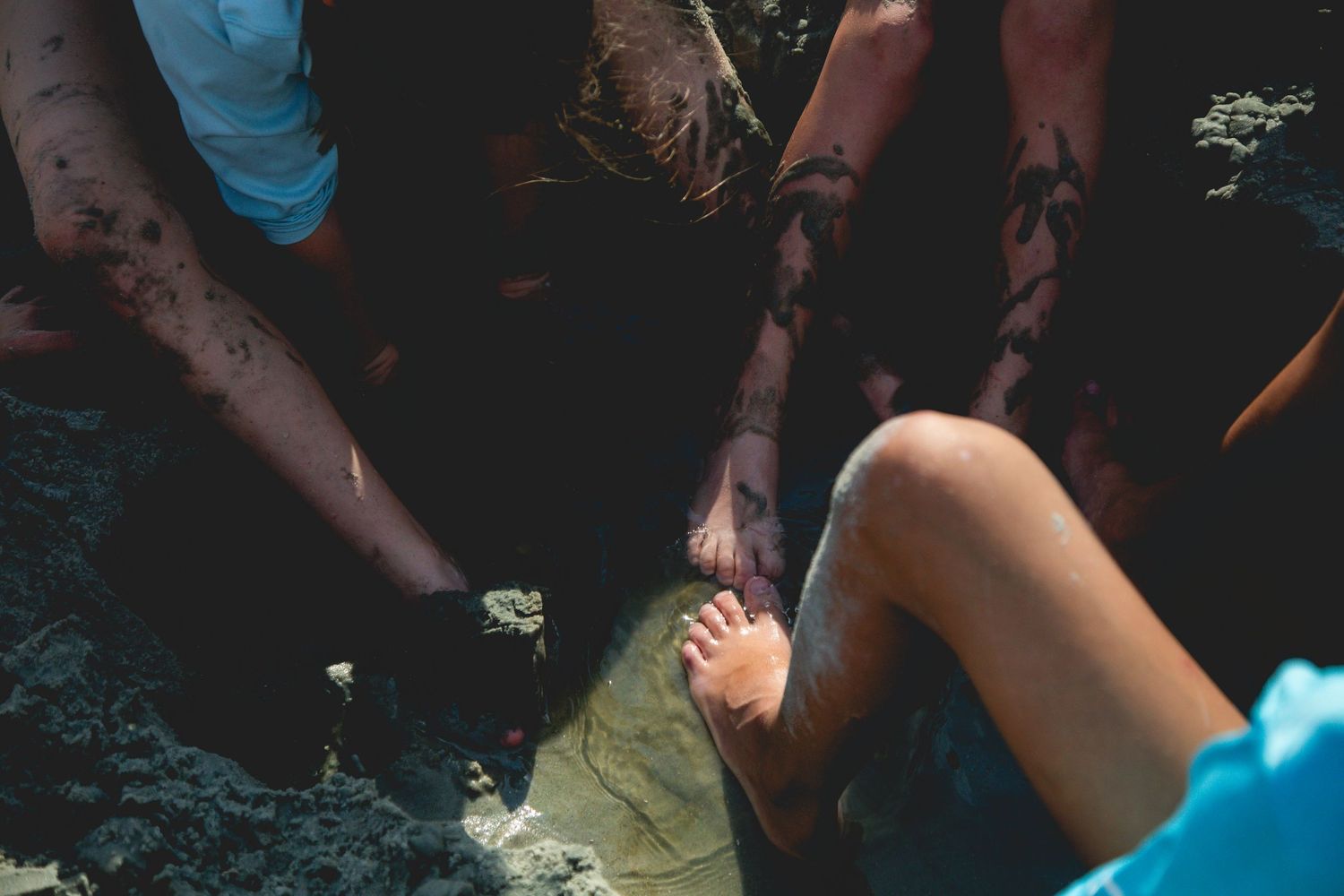 A close-up view of several hands passing out pieces during a DIY craft session.