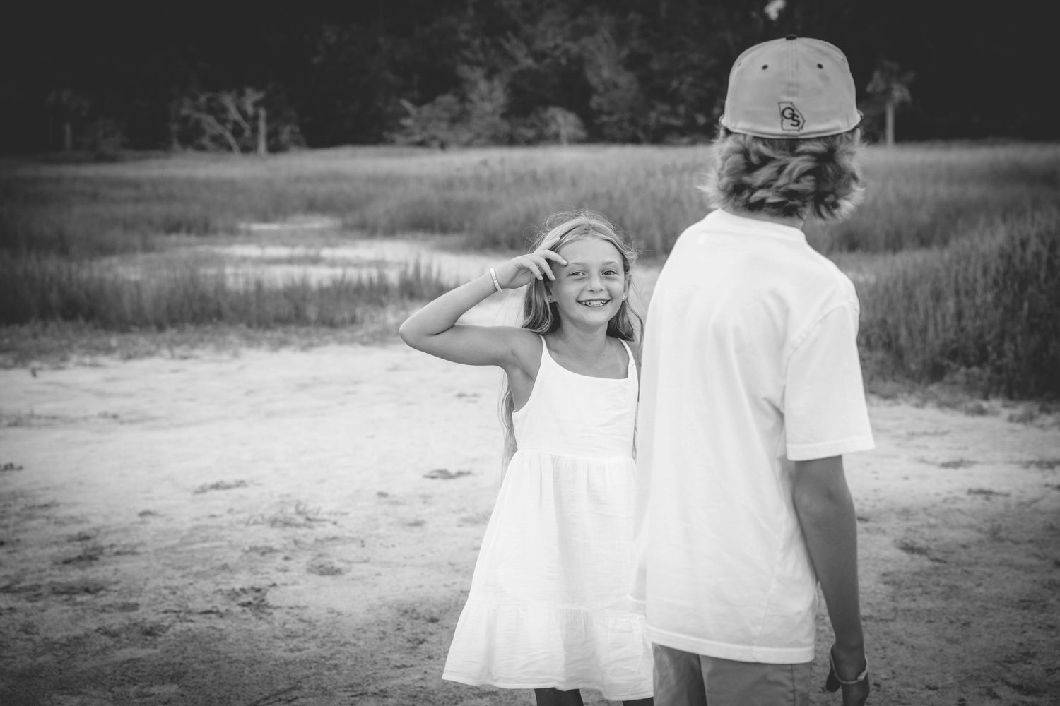 A romantic black and white photo series captures tender moments between a couple outdoors at sunset.