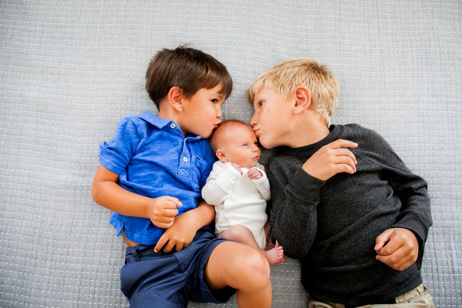 Four sequential images showing siblings sharing sweet kisses and tender moments together.