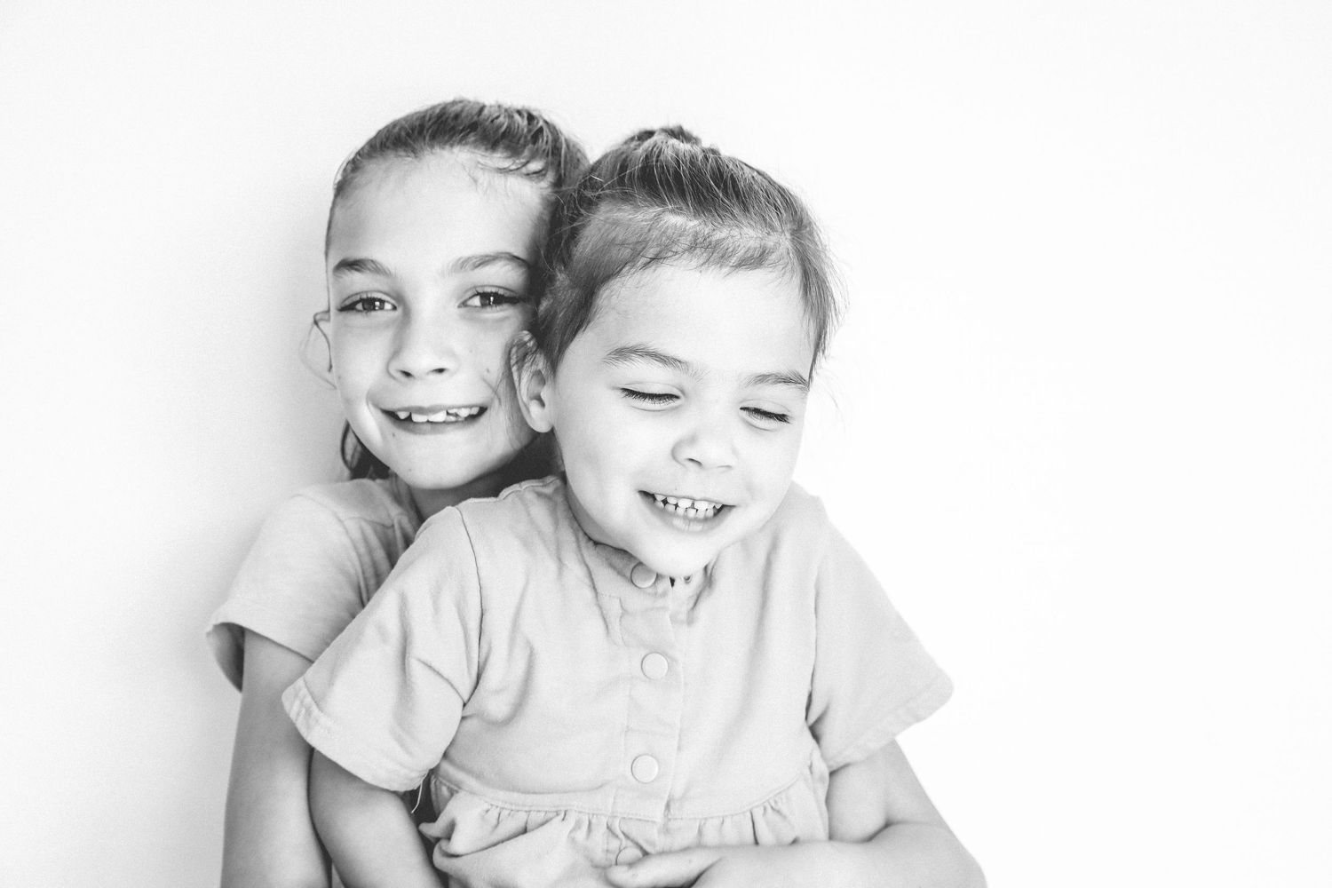 A black and white photo collage of four candid images showing joyful moments and smiles.