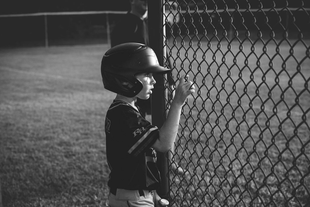 A series of black and white baseball photos showing players and coaches by a chain link fence during a game.