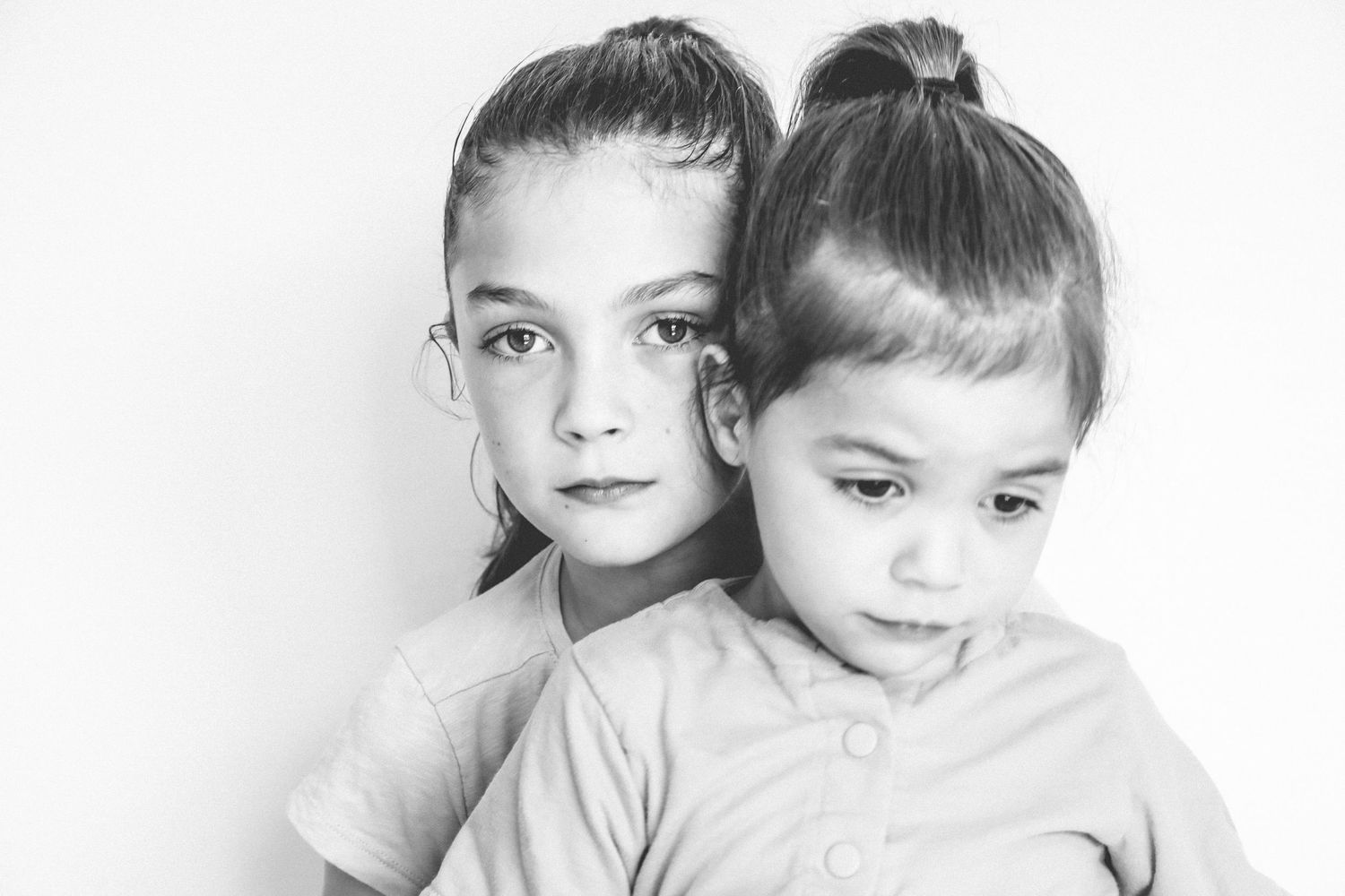 Black and white portrait of multiple children with joyful expressions looking off camera to something exciting.