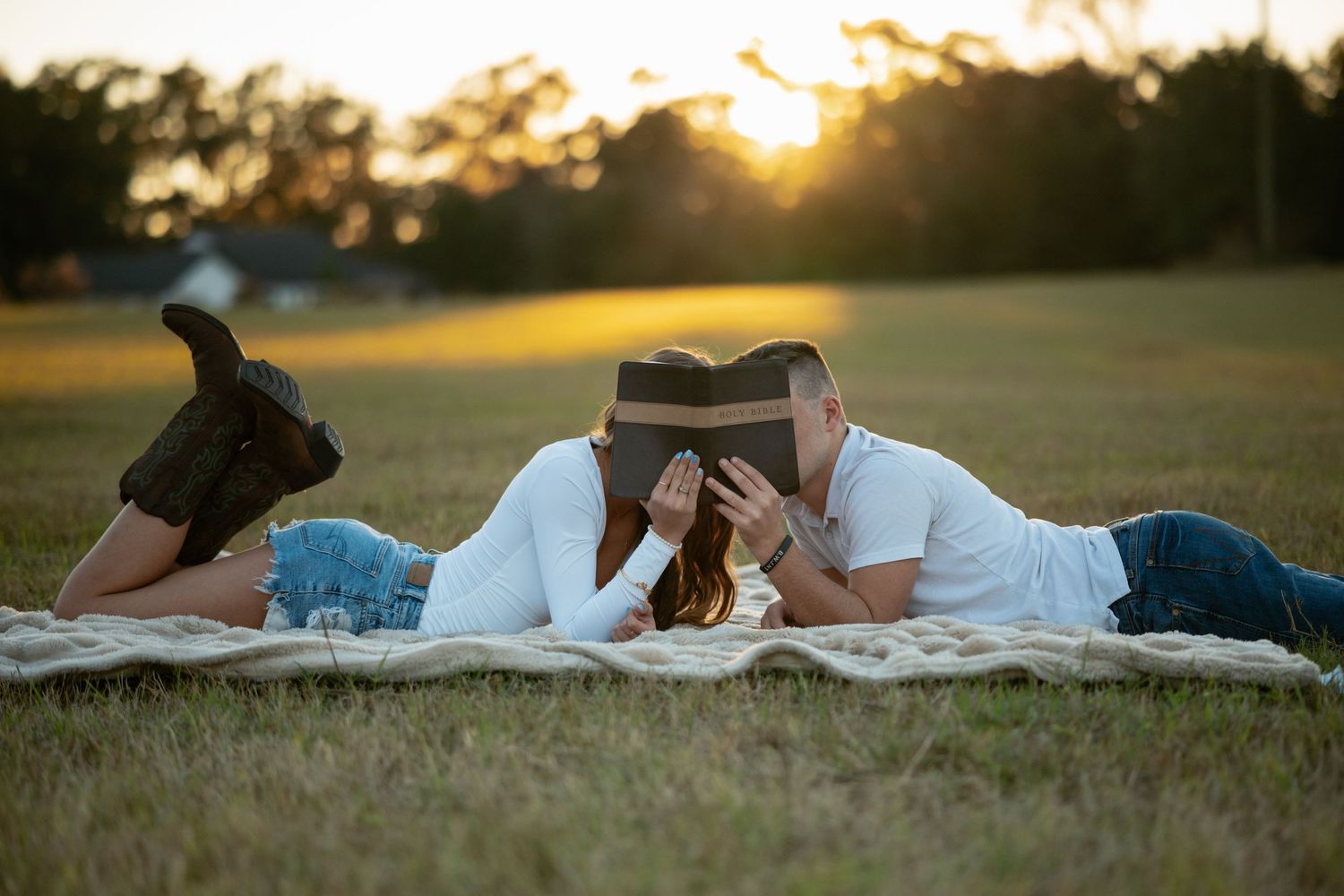 A couple lounges on a blanket during a romantic sunset.