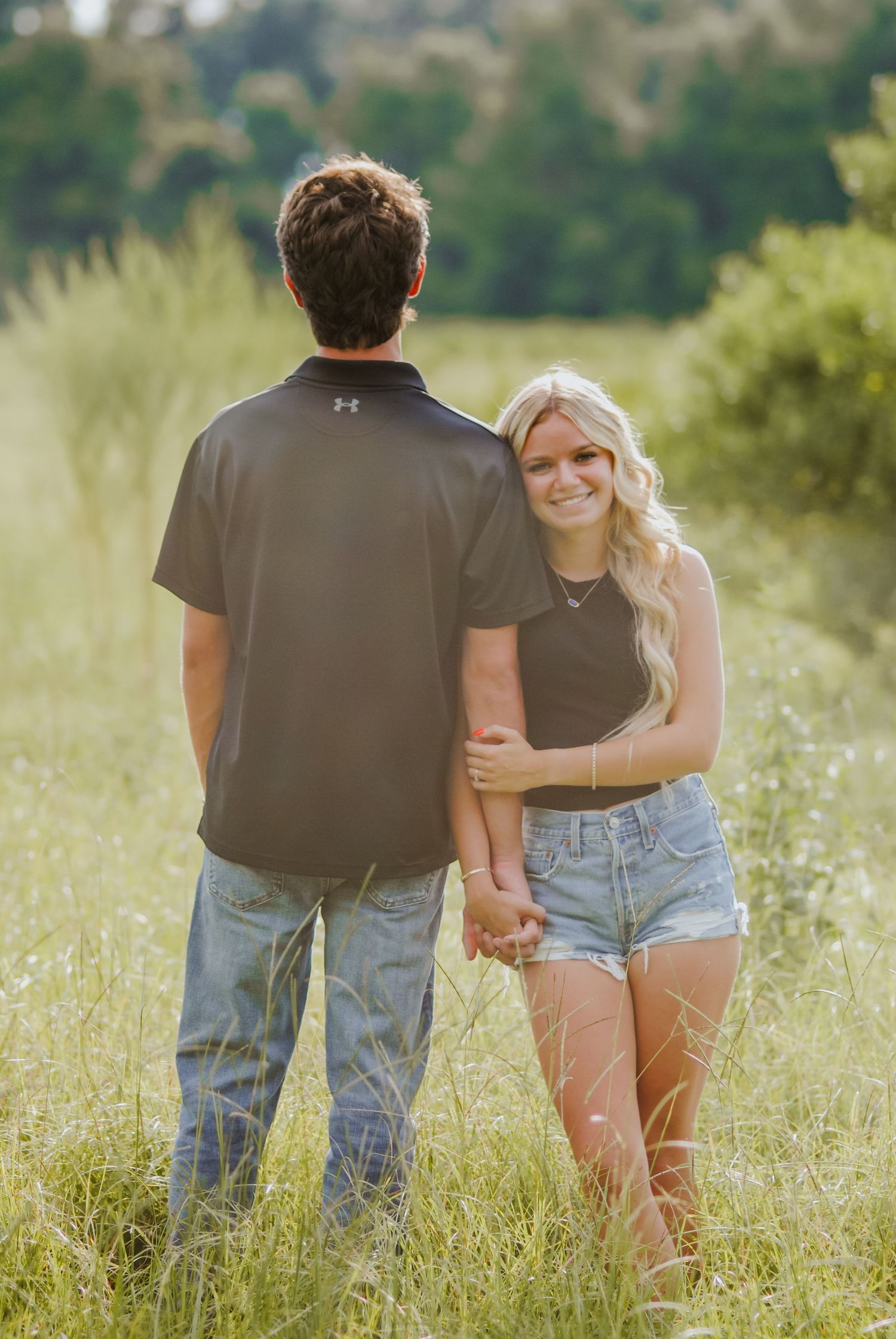 Couple walking together through a wildflower meadow on a summer day.