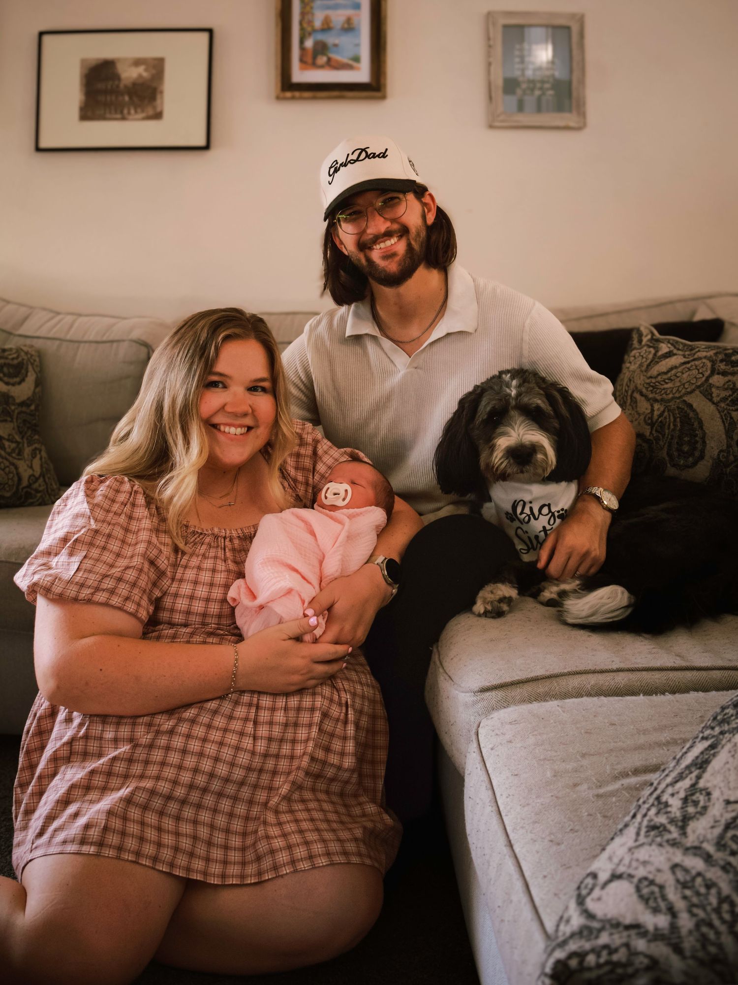 Parents holding their newborn baby with their family dog during a relaxed in-home newborn and family photography session in Colorado Springs