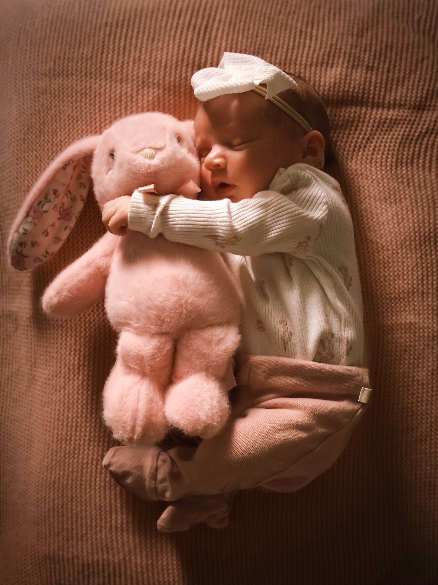 Newborn baby cuddling a stuffed bunny during a sweet in-home newborn portrait session in Colorado Springs, Colorado.