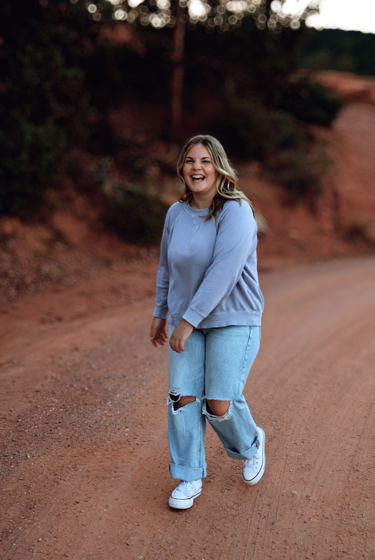 Female high school senior walking along a mountain trail during an outdoor senior photography session at Garden of the Gods in Colorado