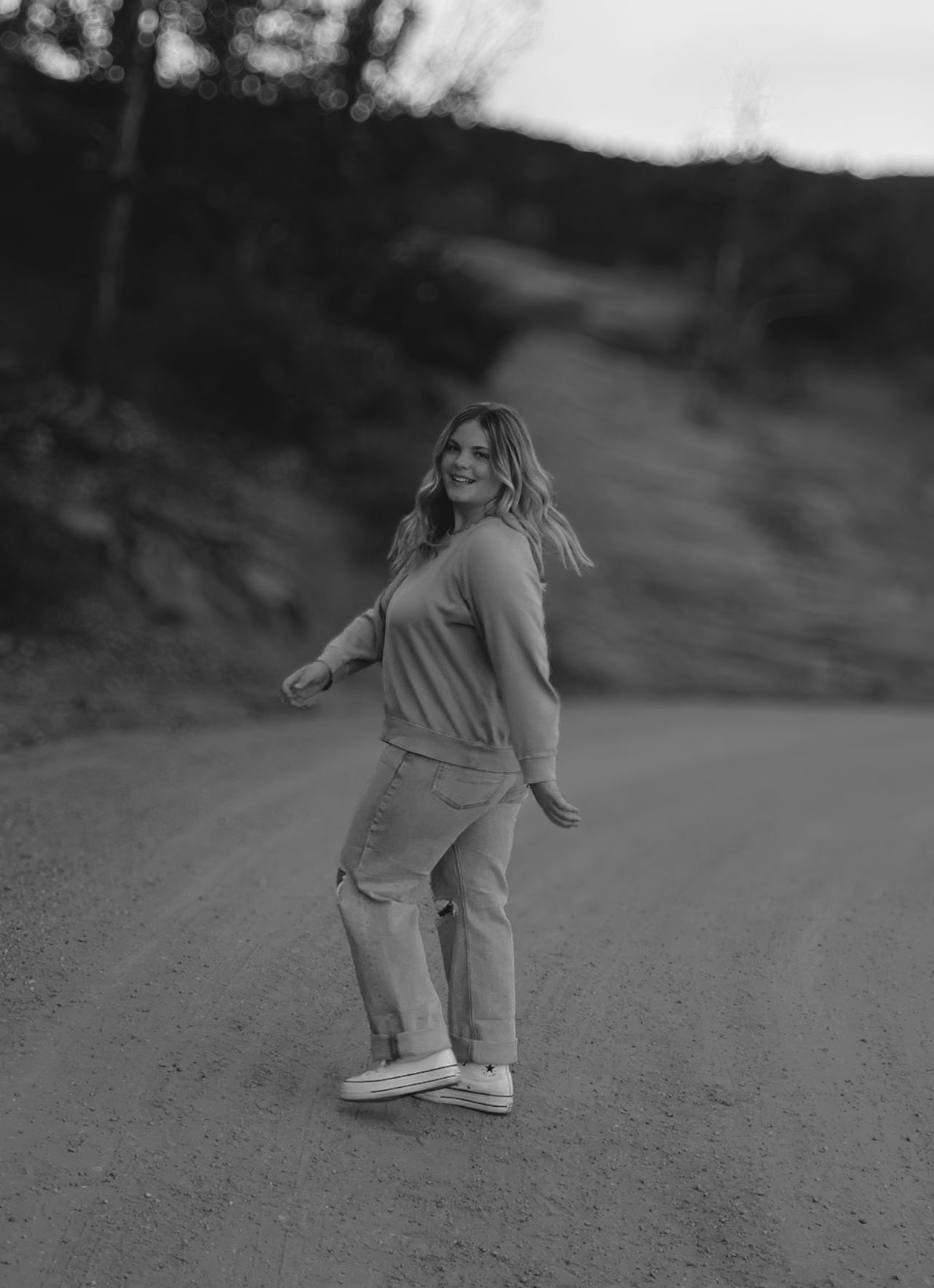 Black and white portrait of a female high school senior walking outdoors during a Garden of the Gods senior photography session.