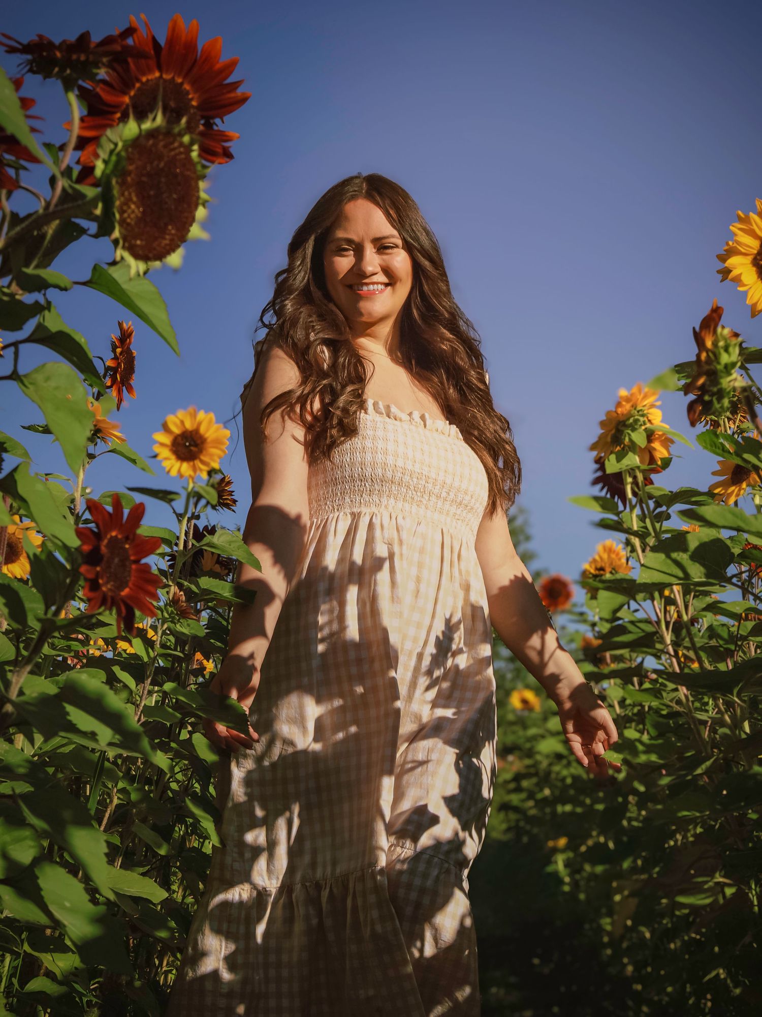 Young woman walking through a colorful flower field with mountain views at Gather Mountain Blooms in Colorado.