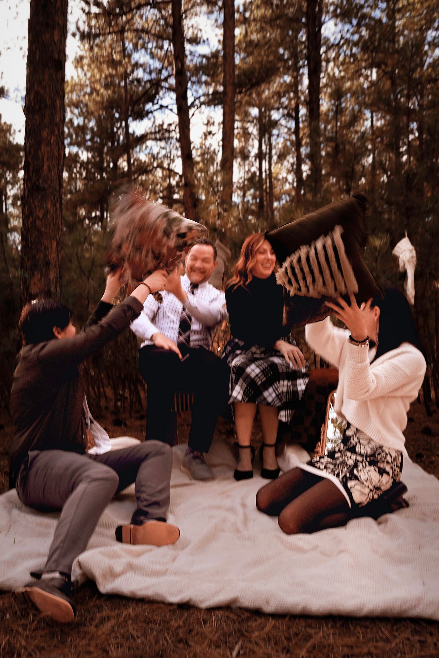 Family gathered together during a Christmas mini photography session among the pine trees at Fox Run Regional Park in Colorado Springs, CO