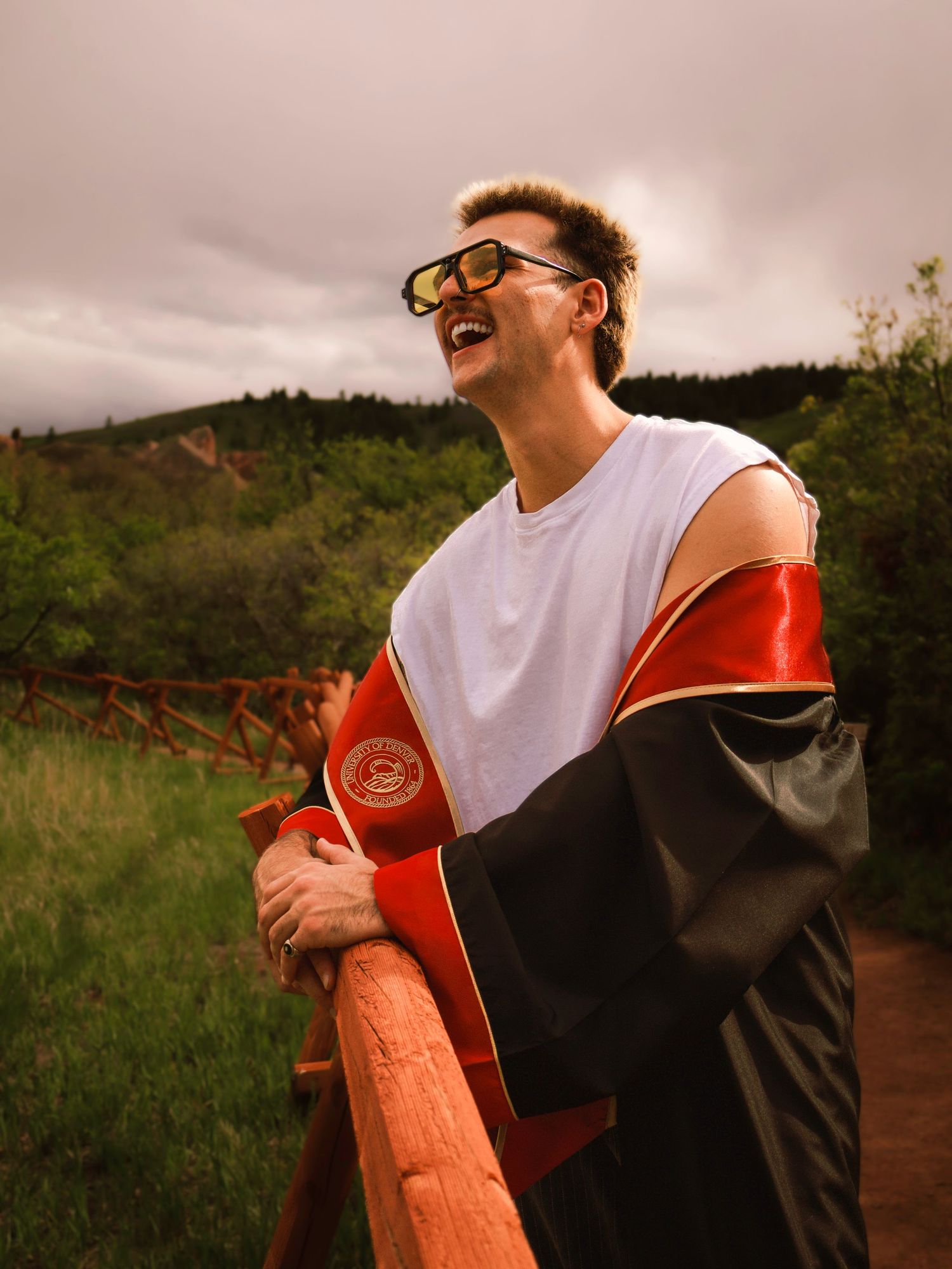 Outdoor graduation portrait
Colorado Springs senior portrait of a male graduate smiling outdoors in his cap and gown with Colorado mountains