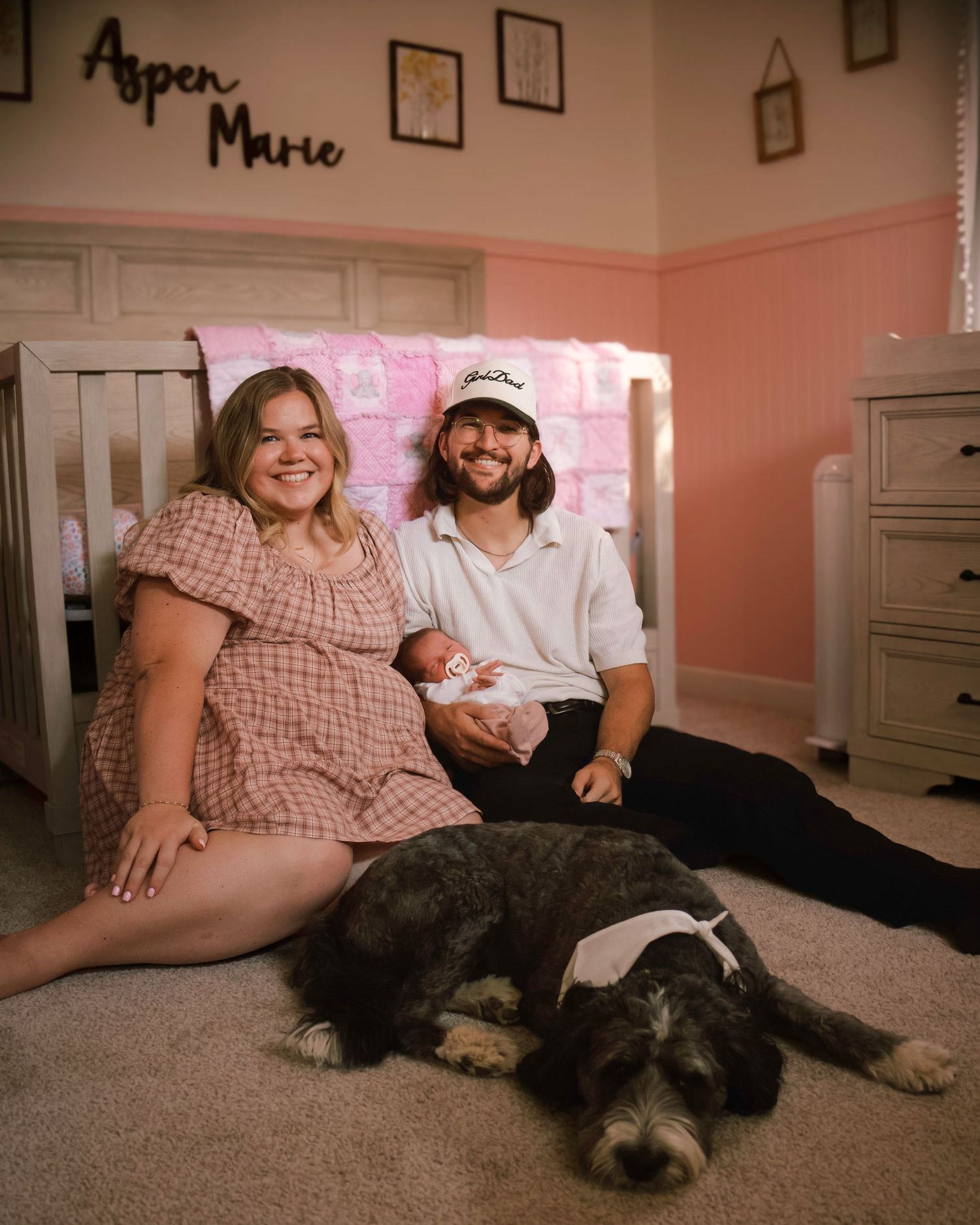 New parents relaxing at home with their family dog during a lifestyle newborn and family photography session in Colorado Springs, Colorado.