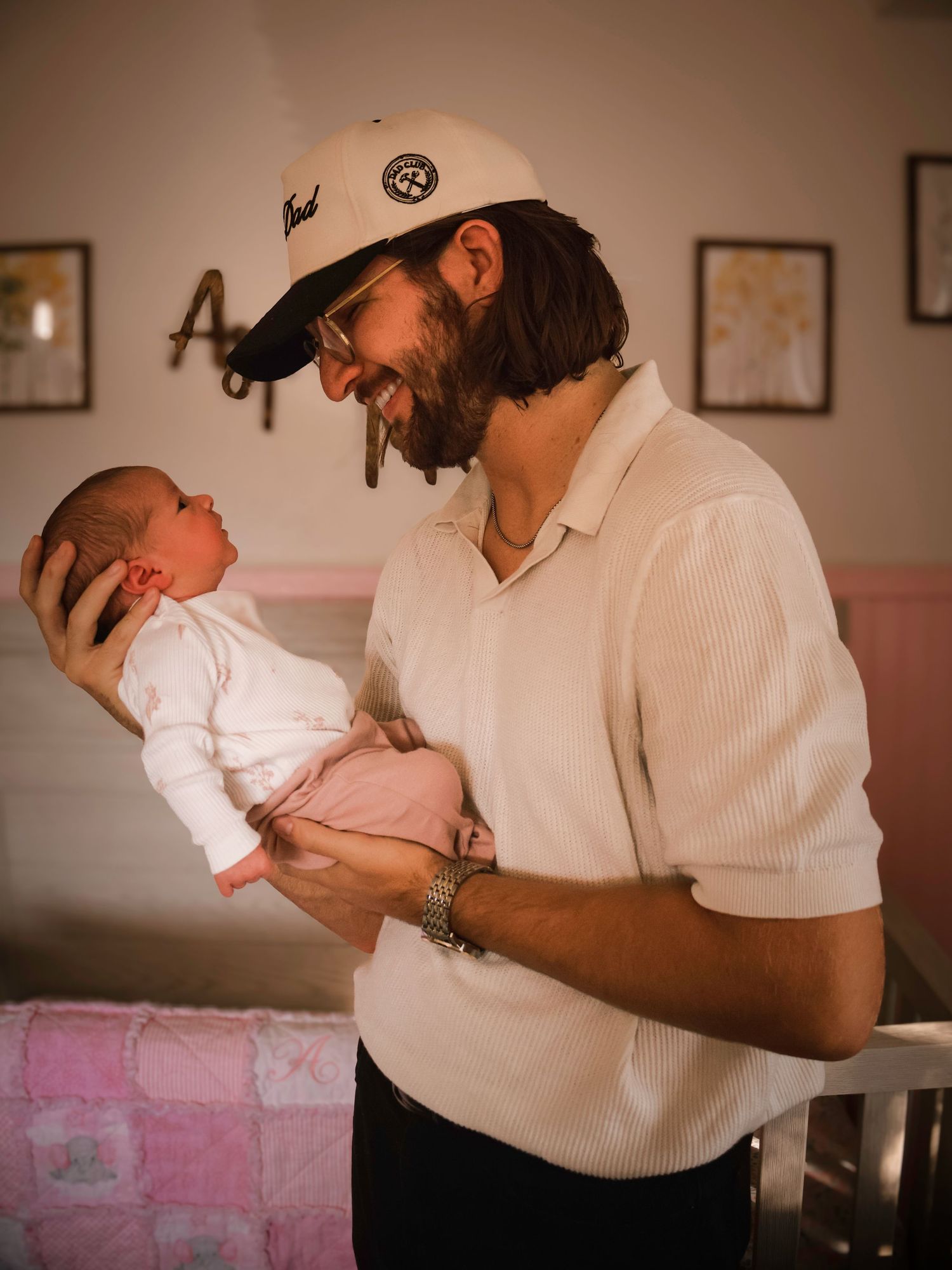 New father smiling while holding his newborn baby during an intimate in-home newborn photography session in Colorado Springs, Colorado.