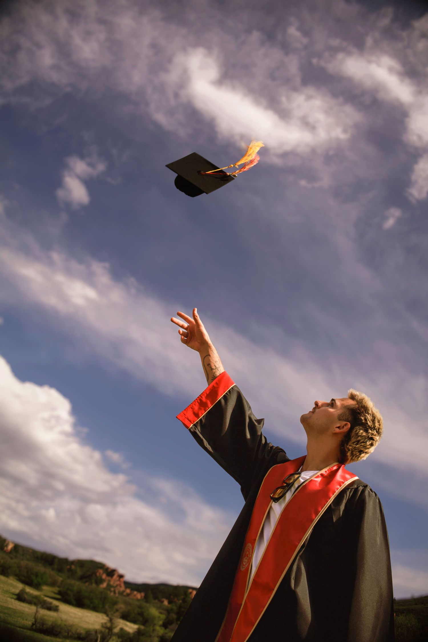 Graduate tossing cap
Colorado Springs senior graduation photo of a graduate tossing his cap into the air against a dramatic Colorado sky.