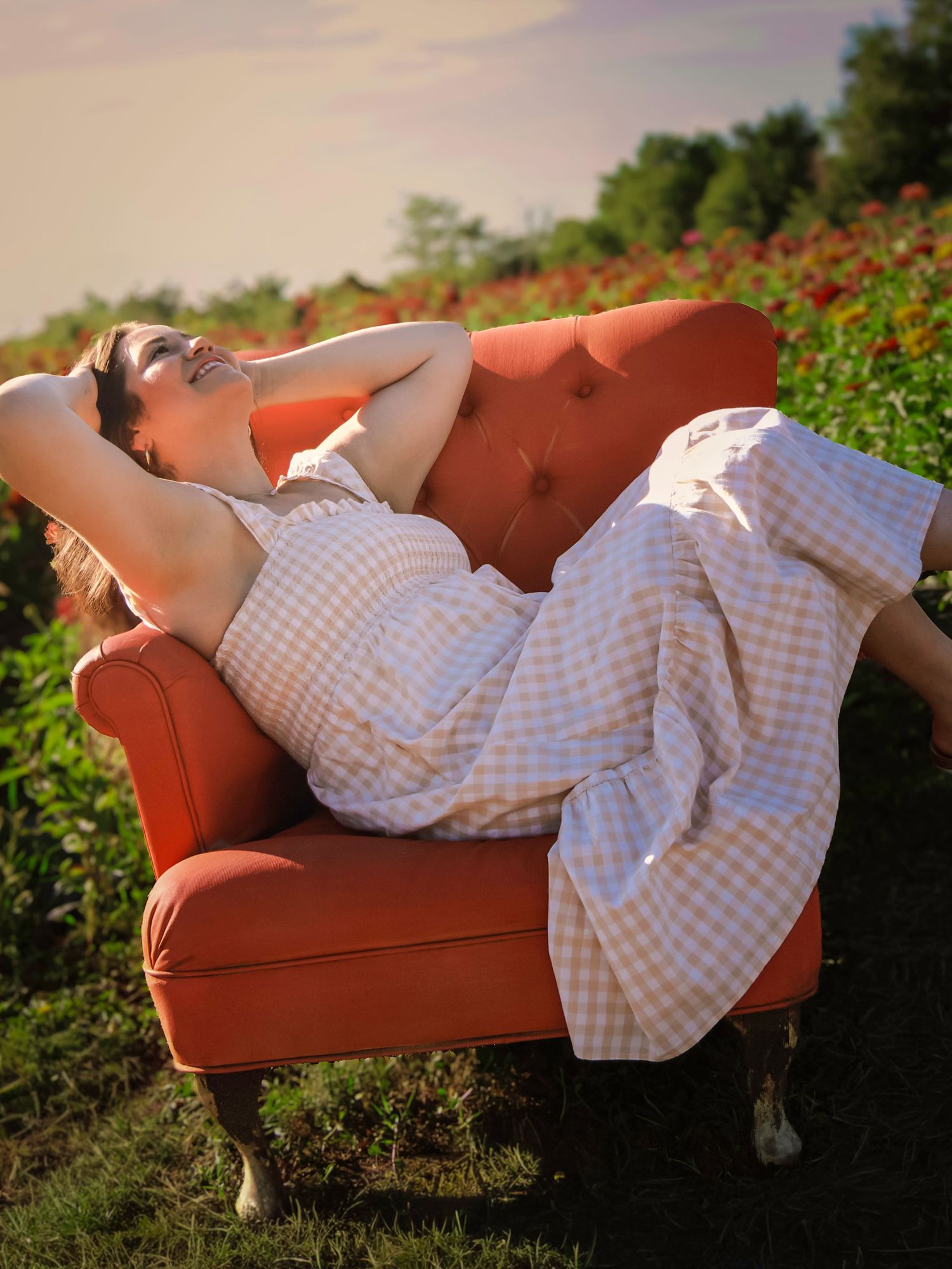 Lifestyle portrait of a young woman relaxing in a chair among colorful flowers at Gather Mountain Blooms.