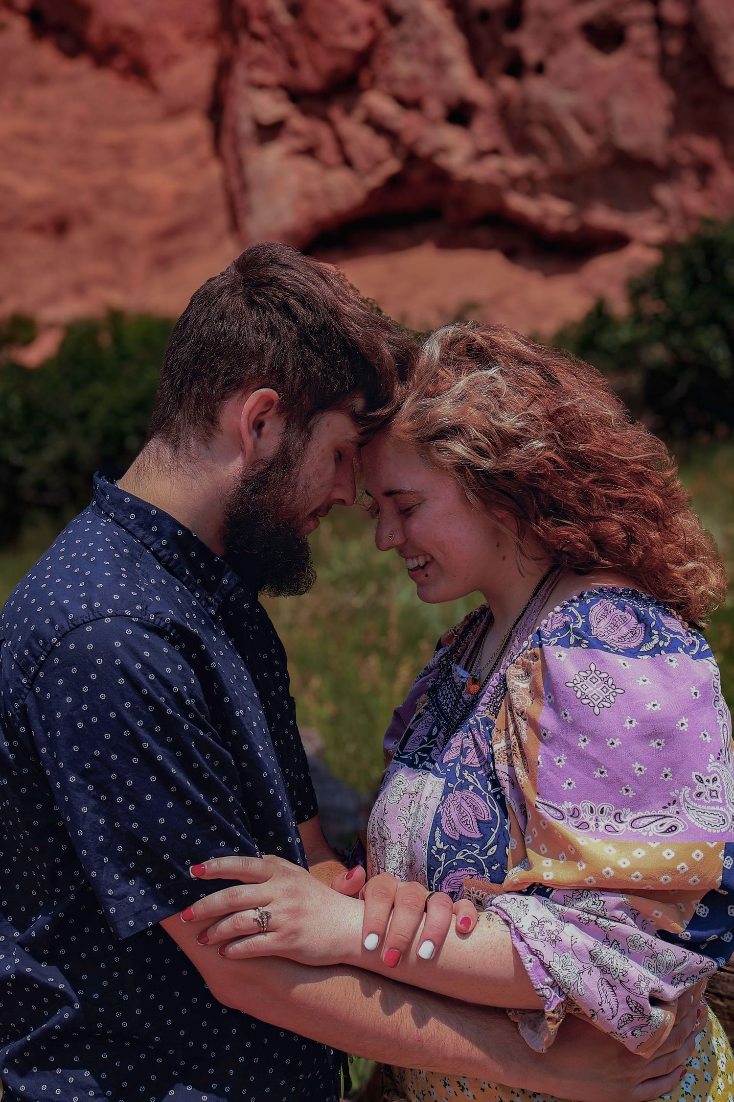 Romantic lifestyle portrait of a couple sharing a quiet moment with red rock formations at Garden of the Gods in Colorado Springs.