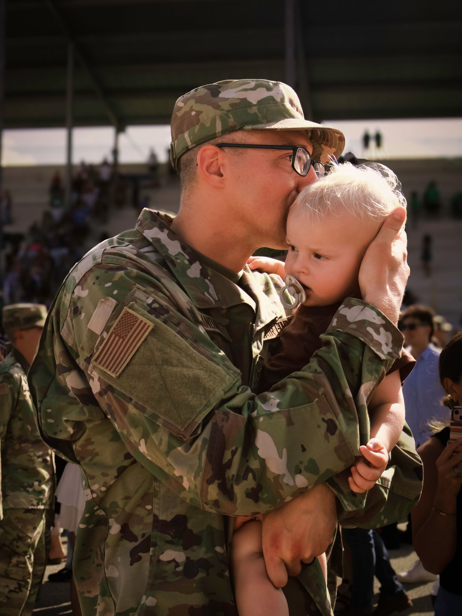 Airman sharing an emotional moment with his baby during an Air Force Academy graduation celebration in Colorado Springs, Colorado.