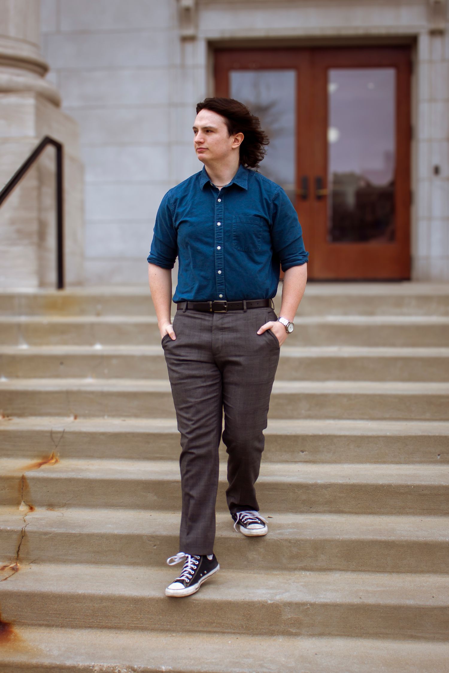 A person in a blue button-down shirt and gray pants is shown walking down concrete steps in multiple poses.