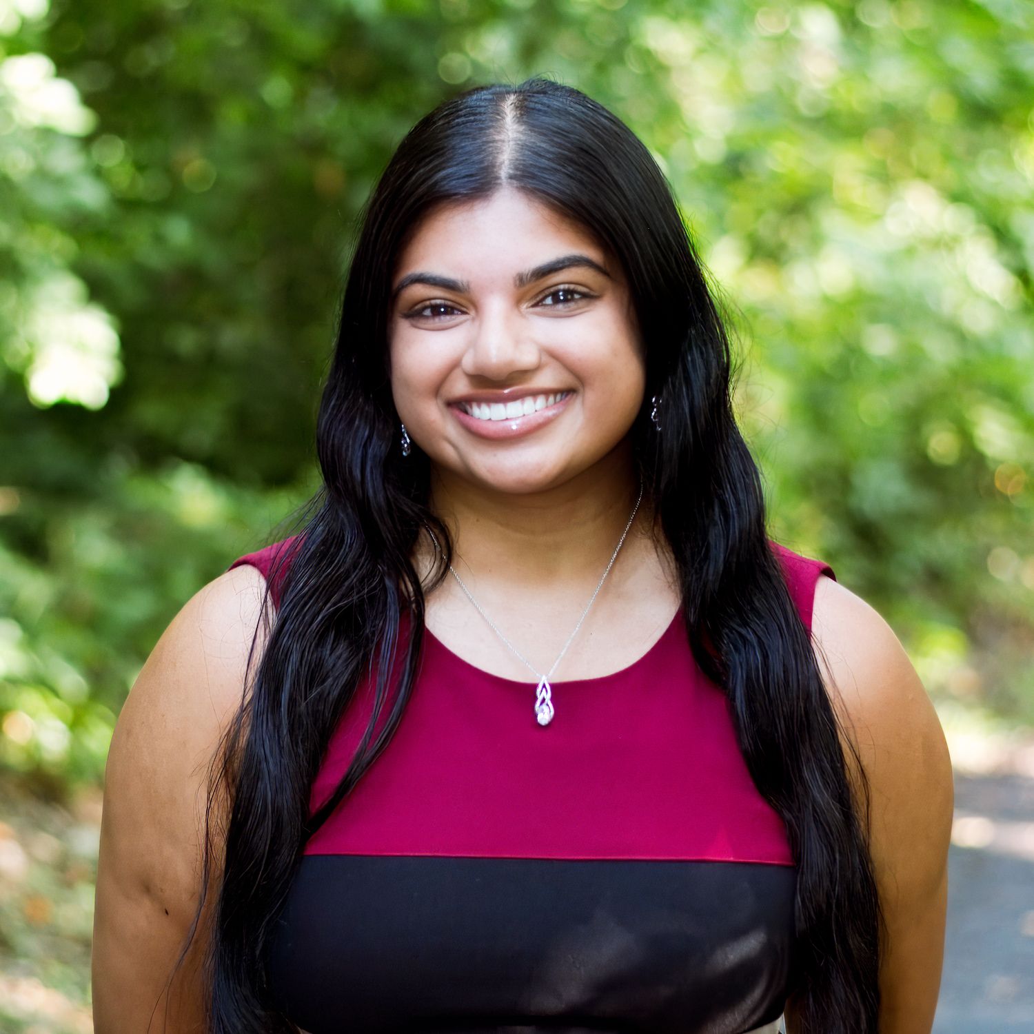 A series of outdoor portrait photos showing someone in burgundy and black tops against a blurred green natural background.