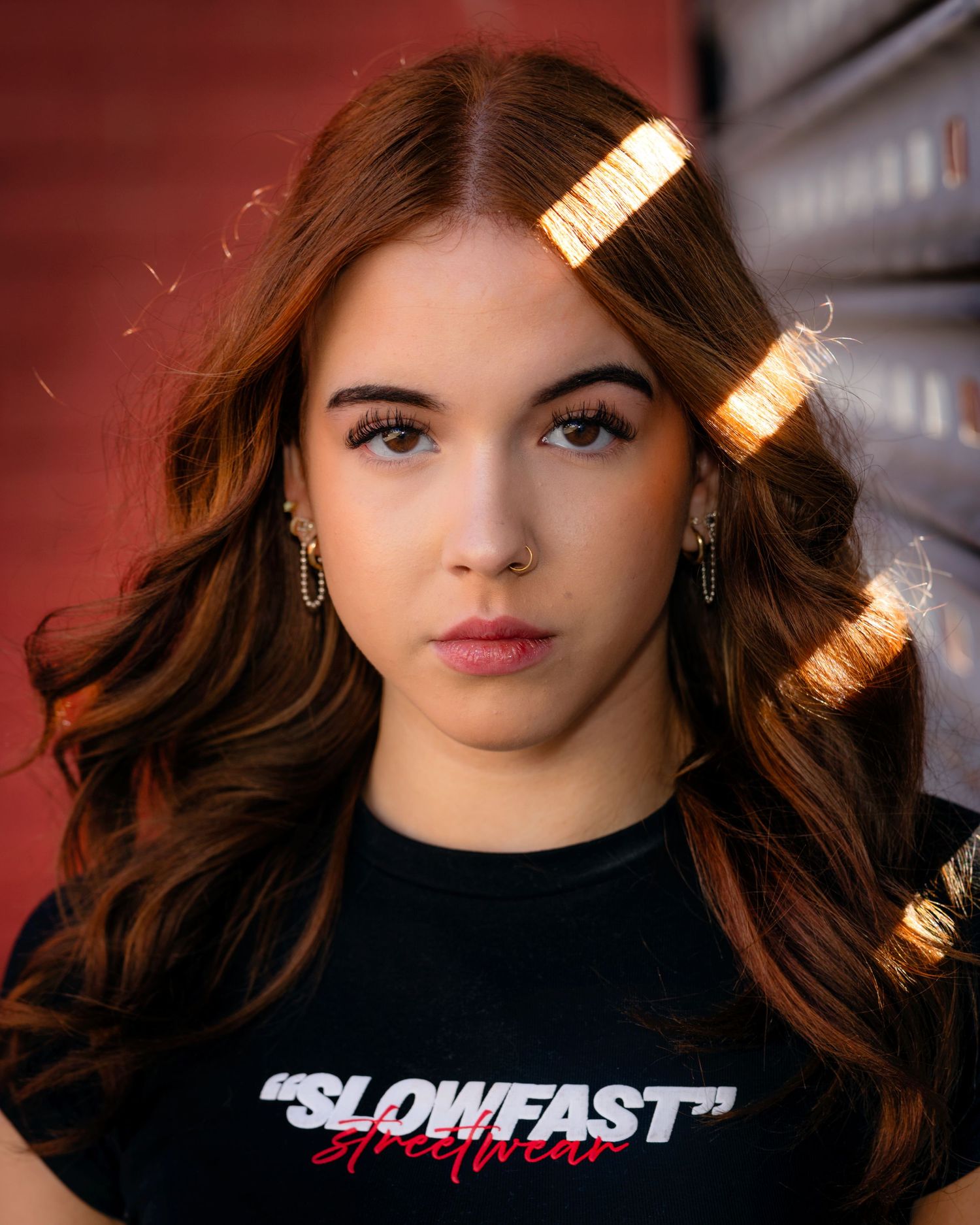 A series of professional portrait photographs showing a person in black attire against moody lighting and backgrounds.