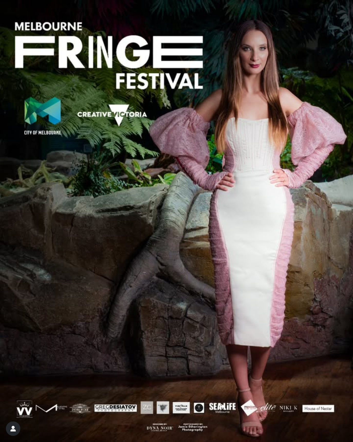 Person in a white mini dress and pink ruffled sleeves poses against a dark rocky backdrop for Melbourne Fringe Festival.