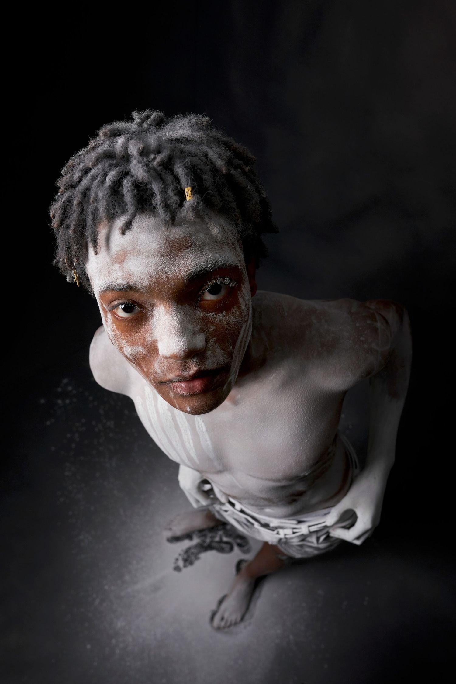 A dark and moody artistic portrait series showing a person in dramatic lighting against a black background.
