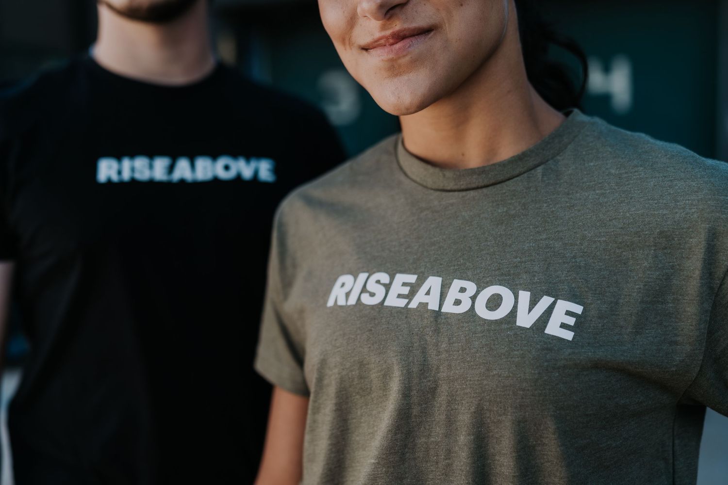Person wearing Rise Above branded t-shirt in close-up brand editorial by Bylitos Studio Michigan