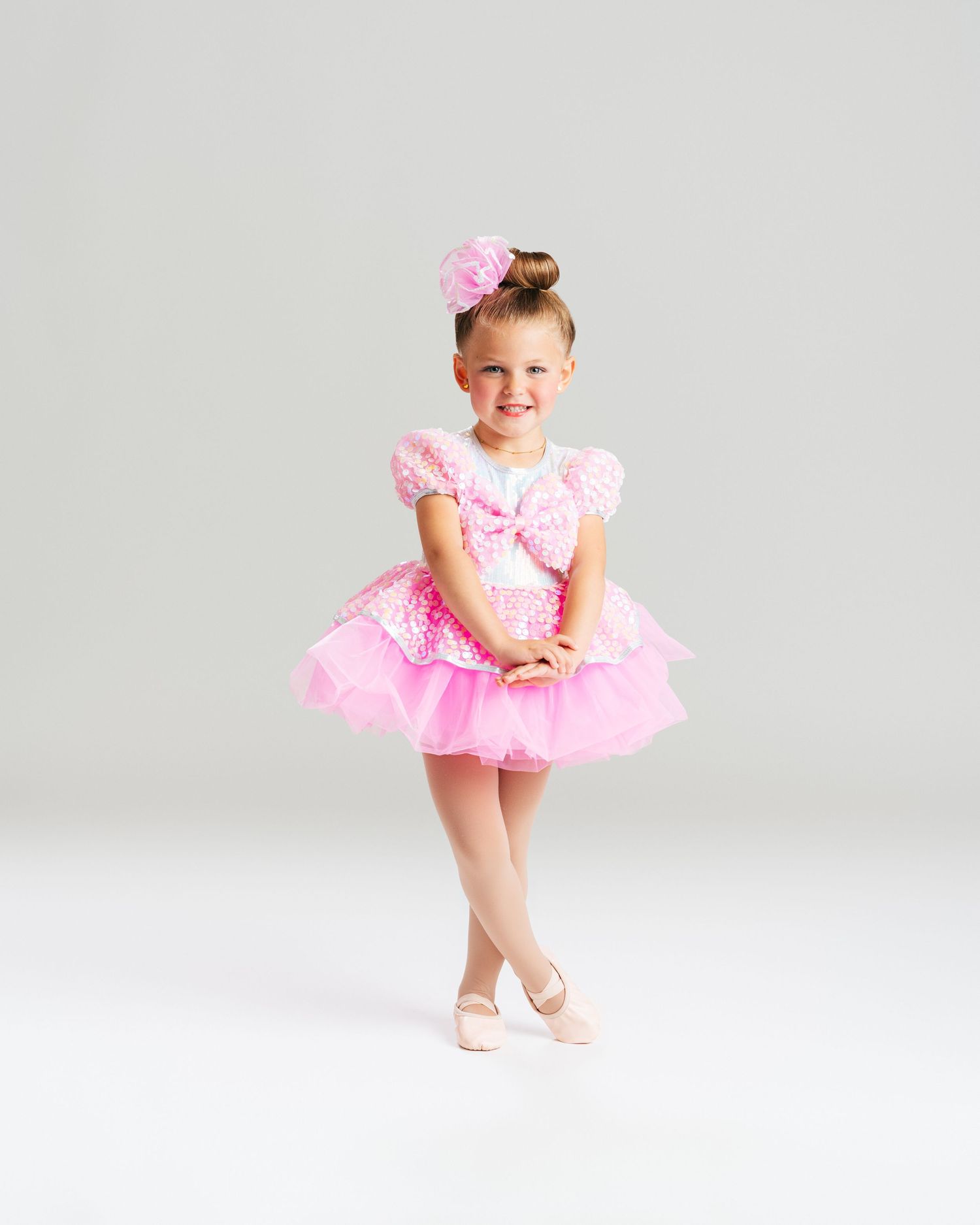 Young ballerina in pink tutu smiling in studio portrait session by Bylitos Studio Michigan