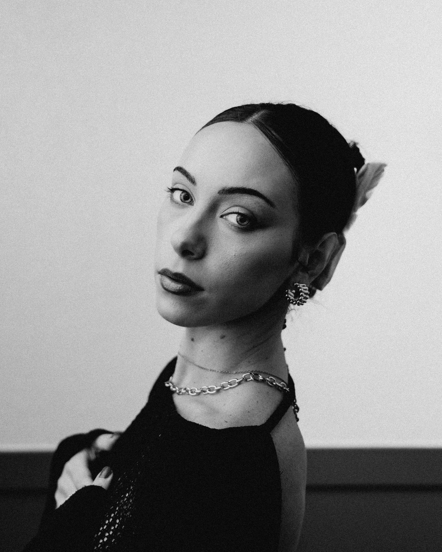 Cinematic black and white close-up portrait of woman with chain necklace by Bylitos Studio Michigan