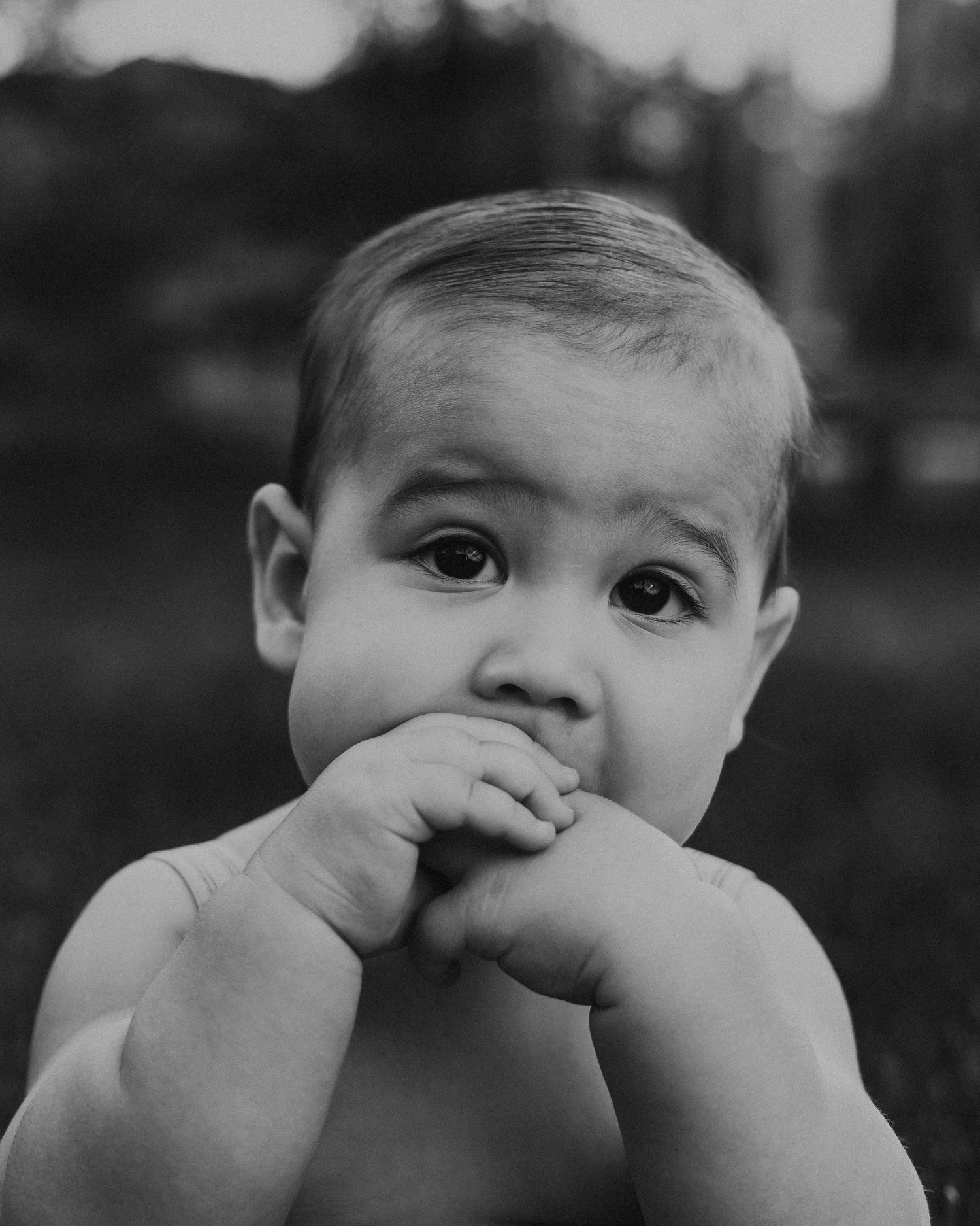 Black and white close-up portrait of a curious baby during family lifestyle session by Bylitos Studio Michigan