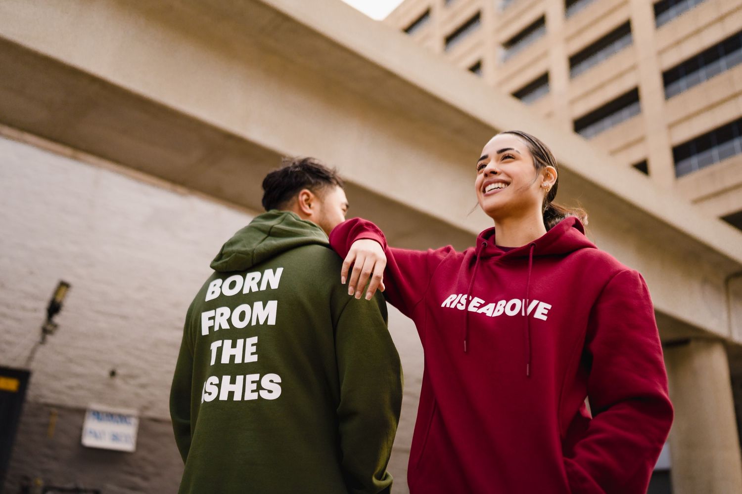 Two models in Rise Above branded hoodies in urban setting for brand editorial by Bylitos Studio Michigan
