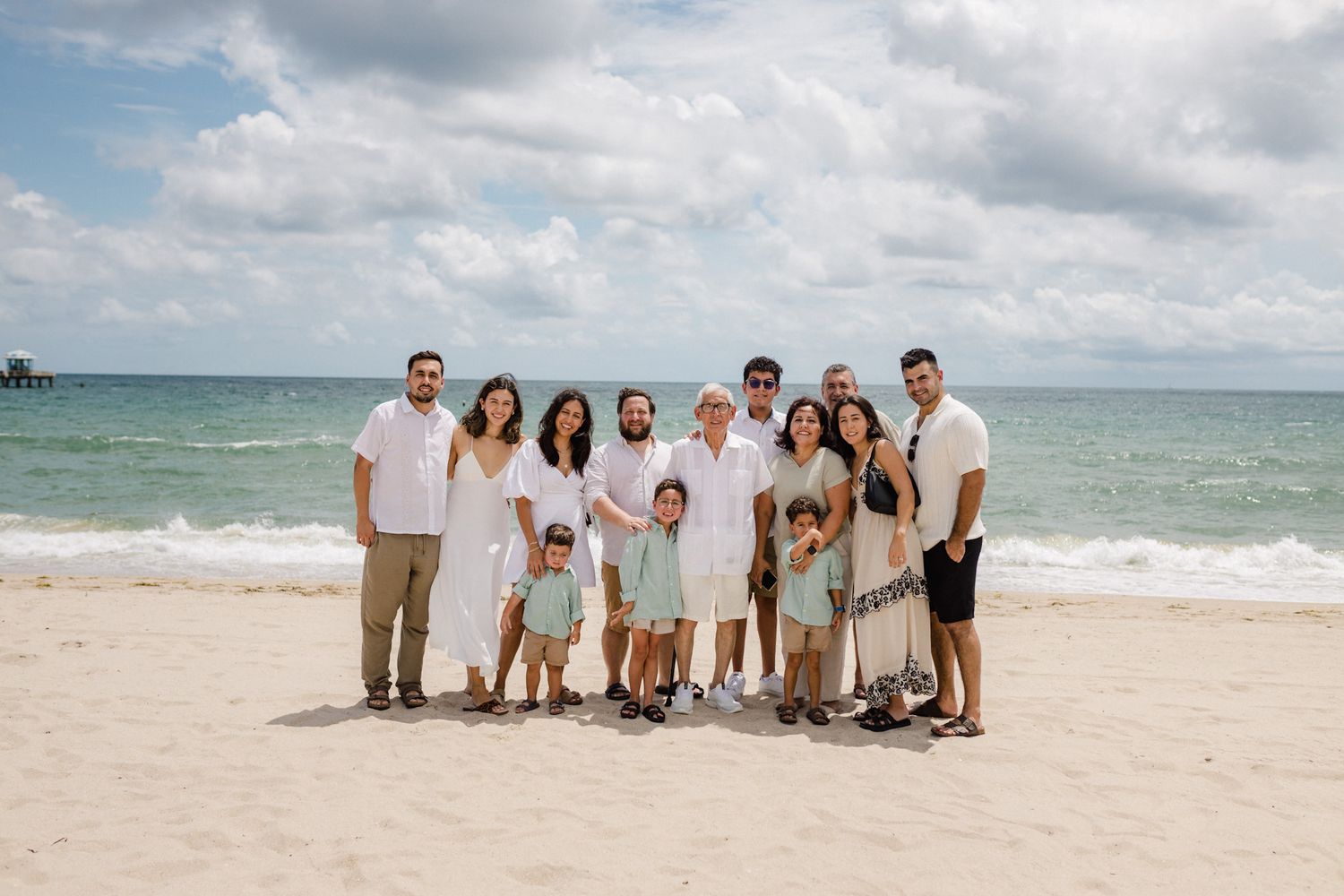 Extended family group portrait on a sunny beach in a lifestyle session by Bylitos Studio Michigan