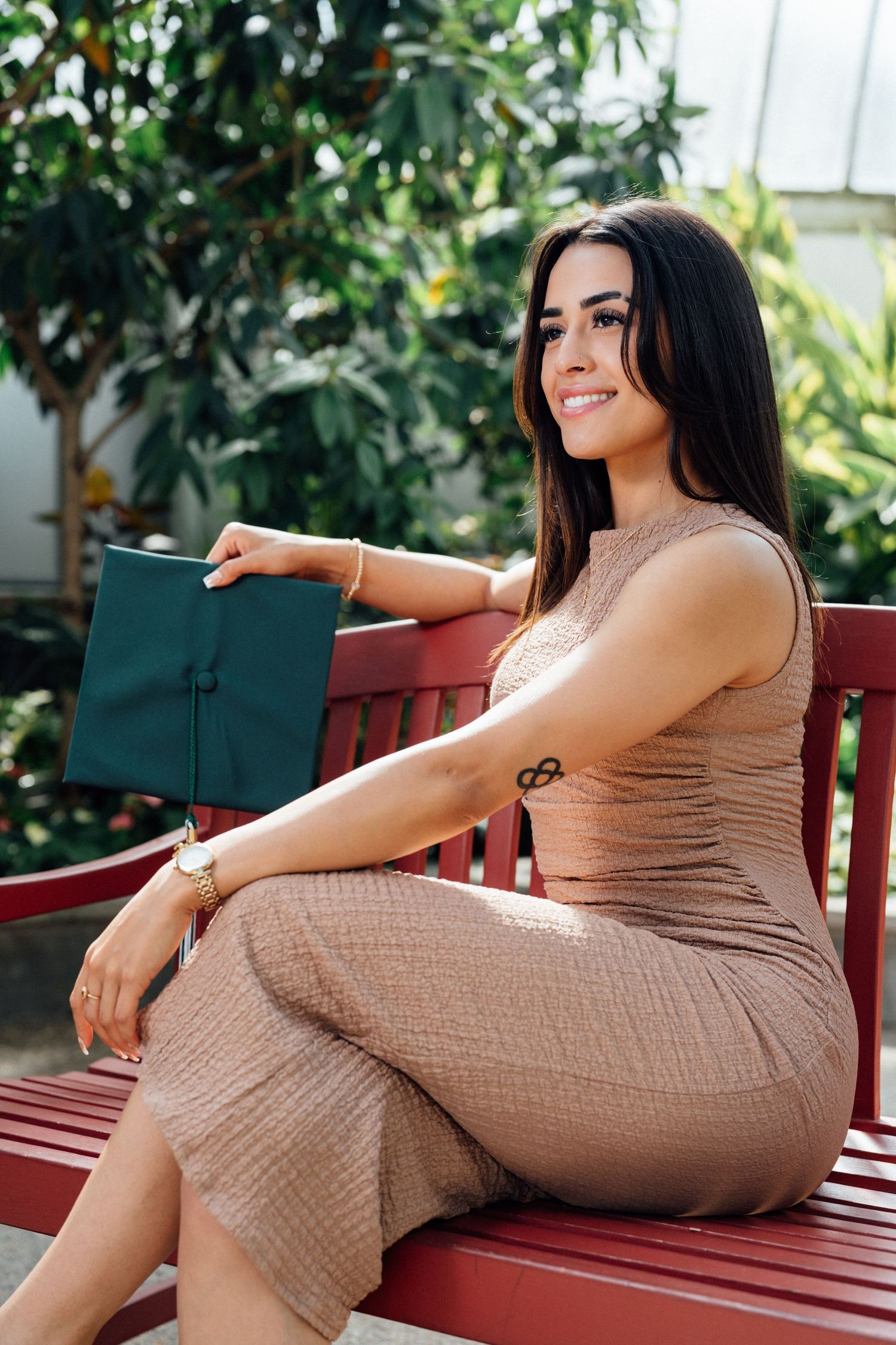 Woman in tan dress seated elegantly on a bench outdoors in lifestyle portrait by Bylitos Studio Michigan