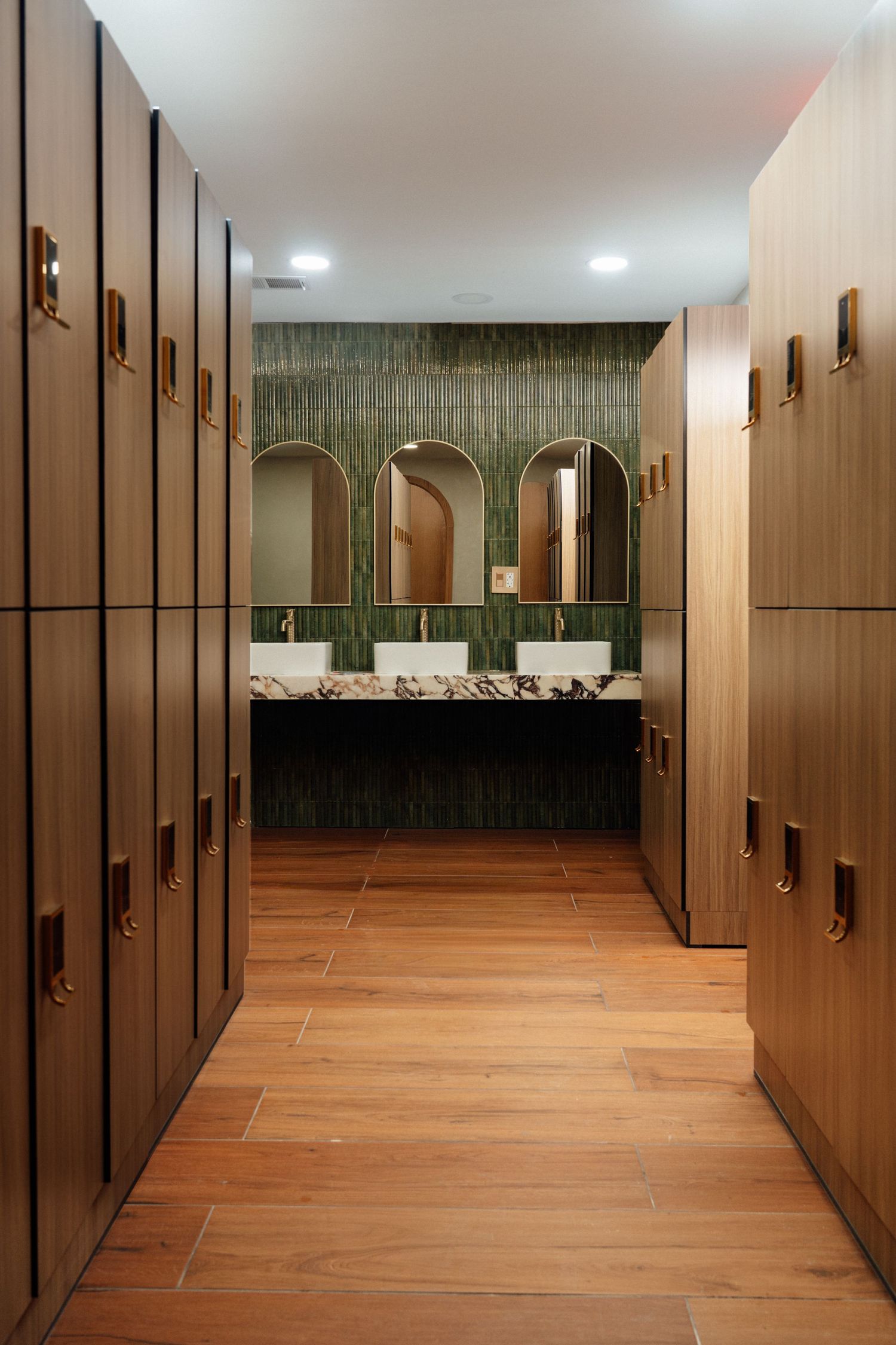 Hallway with wooden lockers and arched doorway in elegant Michigan fitness studio by Bylitos Studio Michigan